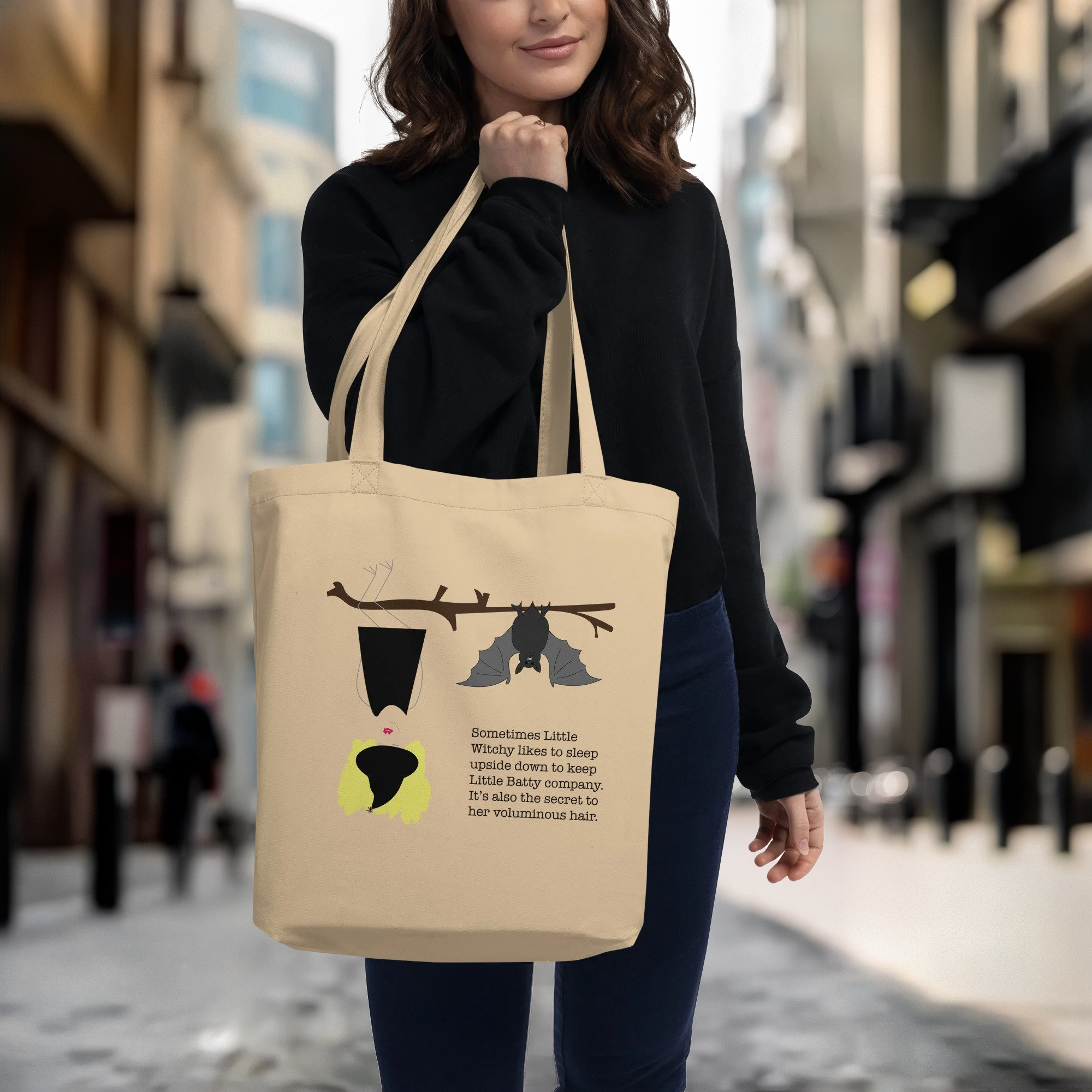 Girl holding Little Witchy canvas tote bag on city street
