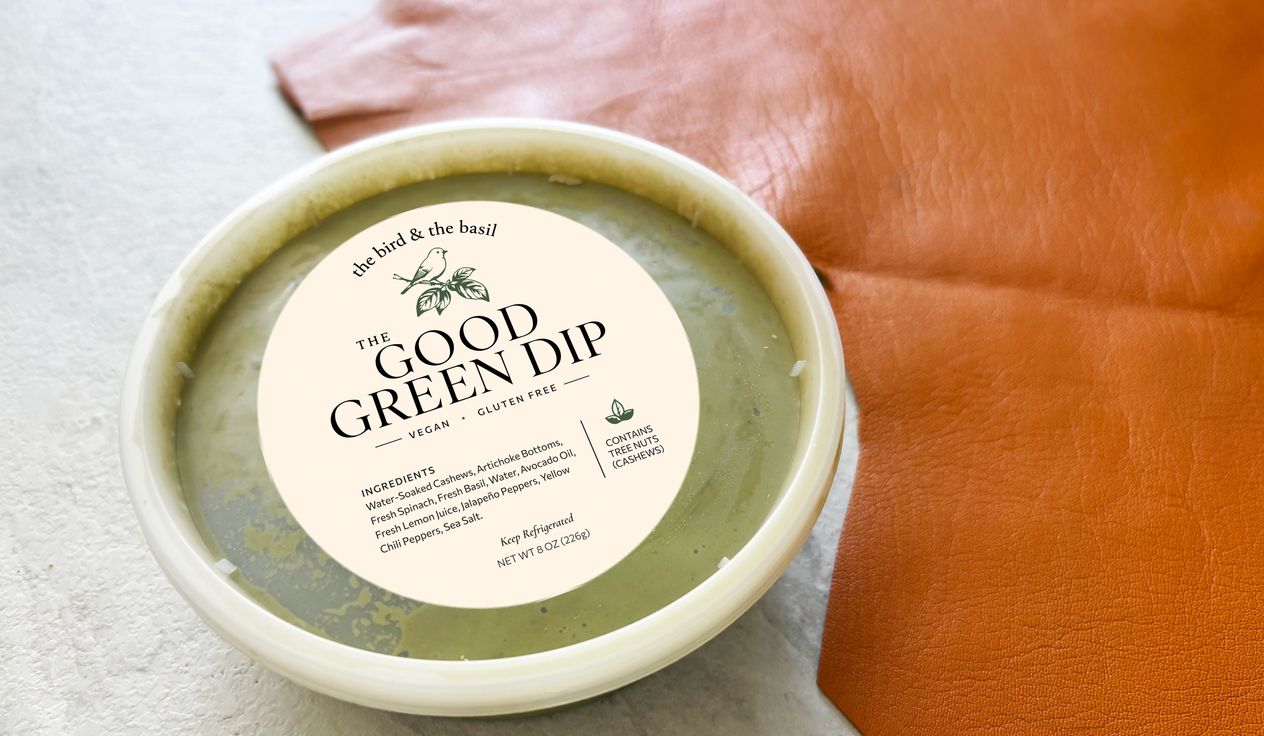 The Good Green Dip on white table with camel colored leather