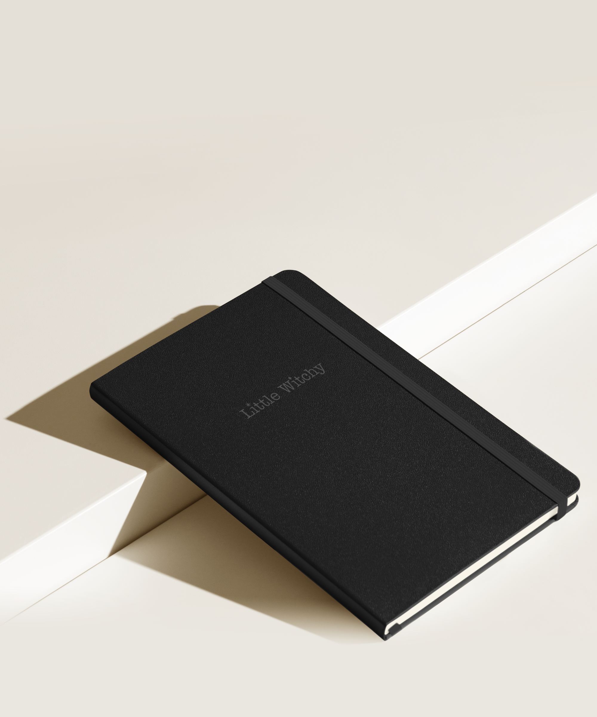 Little Witchy notebook on minimal background with shadow from sun
