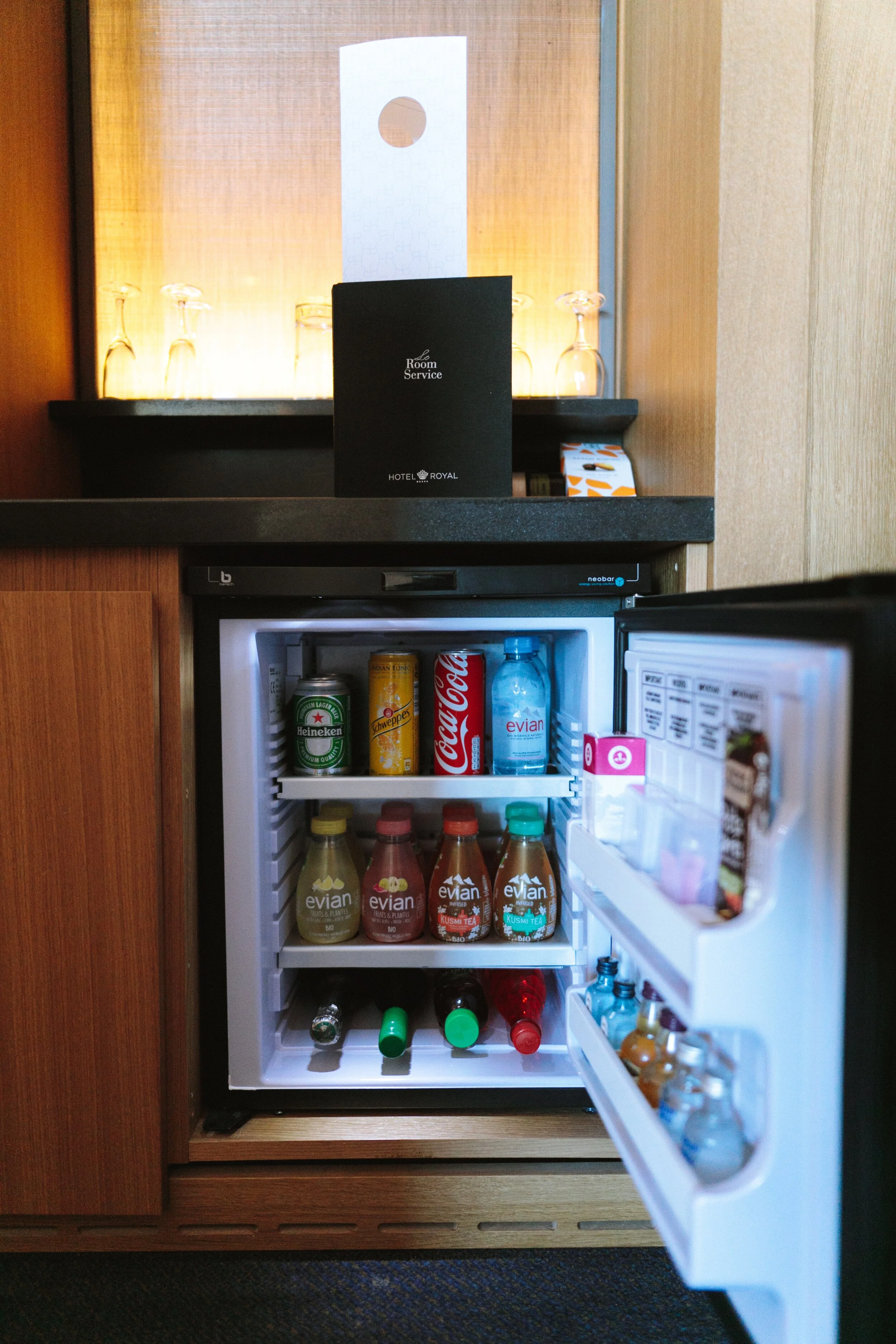An image of an open minifridge showing various bottles and snacks.