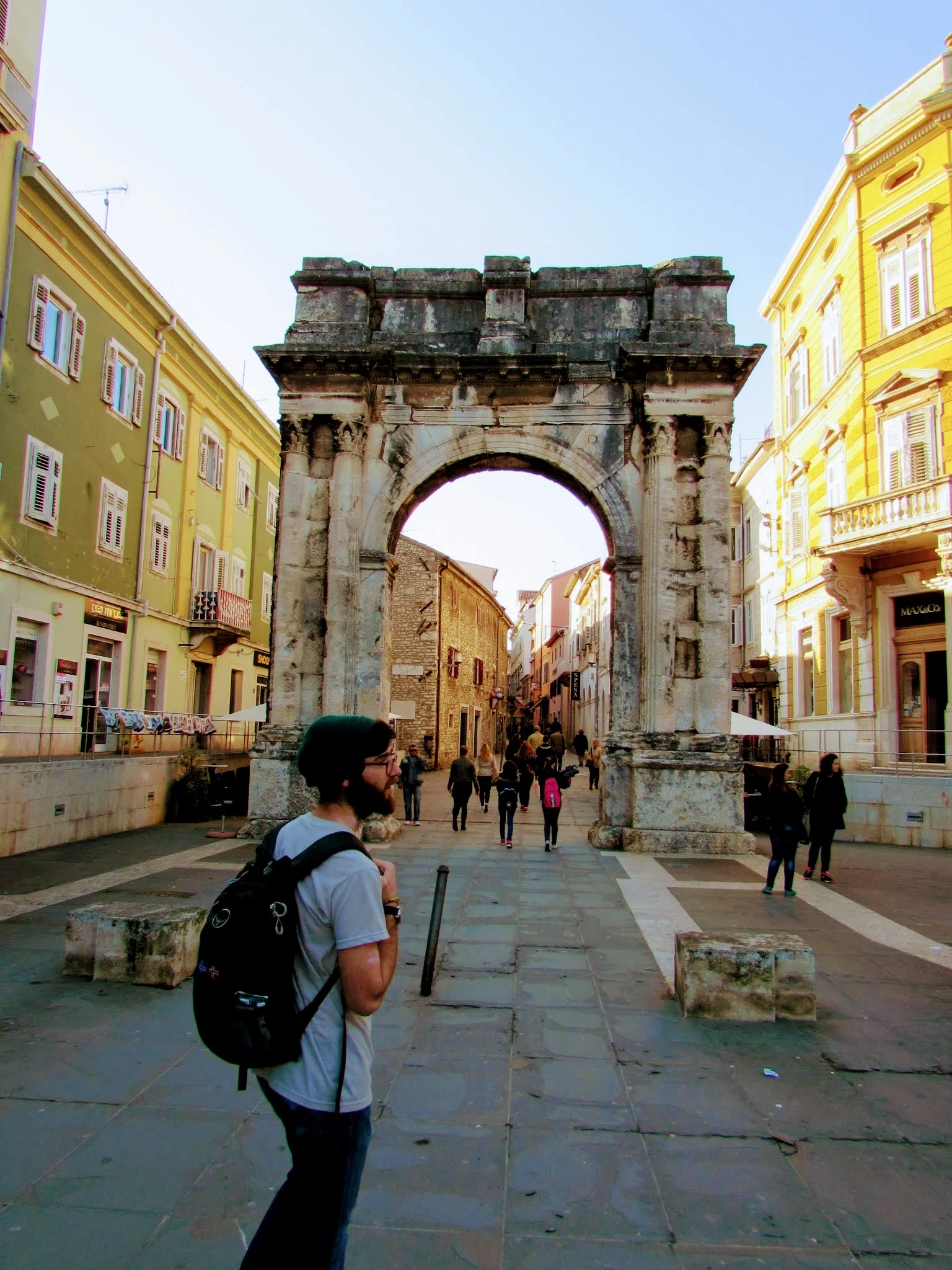 Emmett about to walk through the Arch of Sergii, a Roman triumphal arch in downtown Pula.