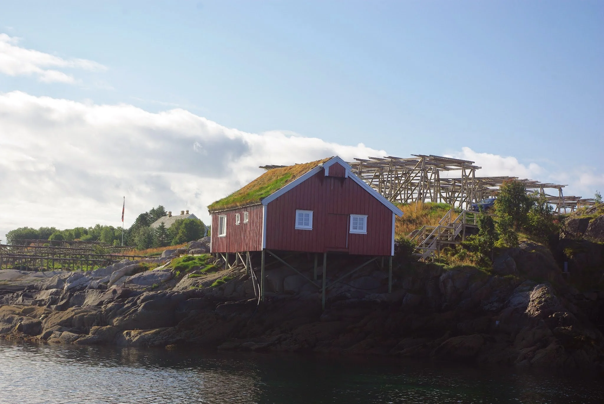 A traditional sod roof on a fjord-side building near Reine. You can also see some cod-drying racks behind it, a common sight in the area.