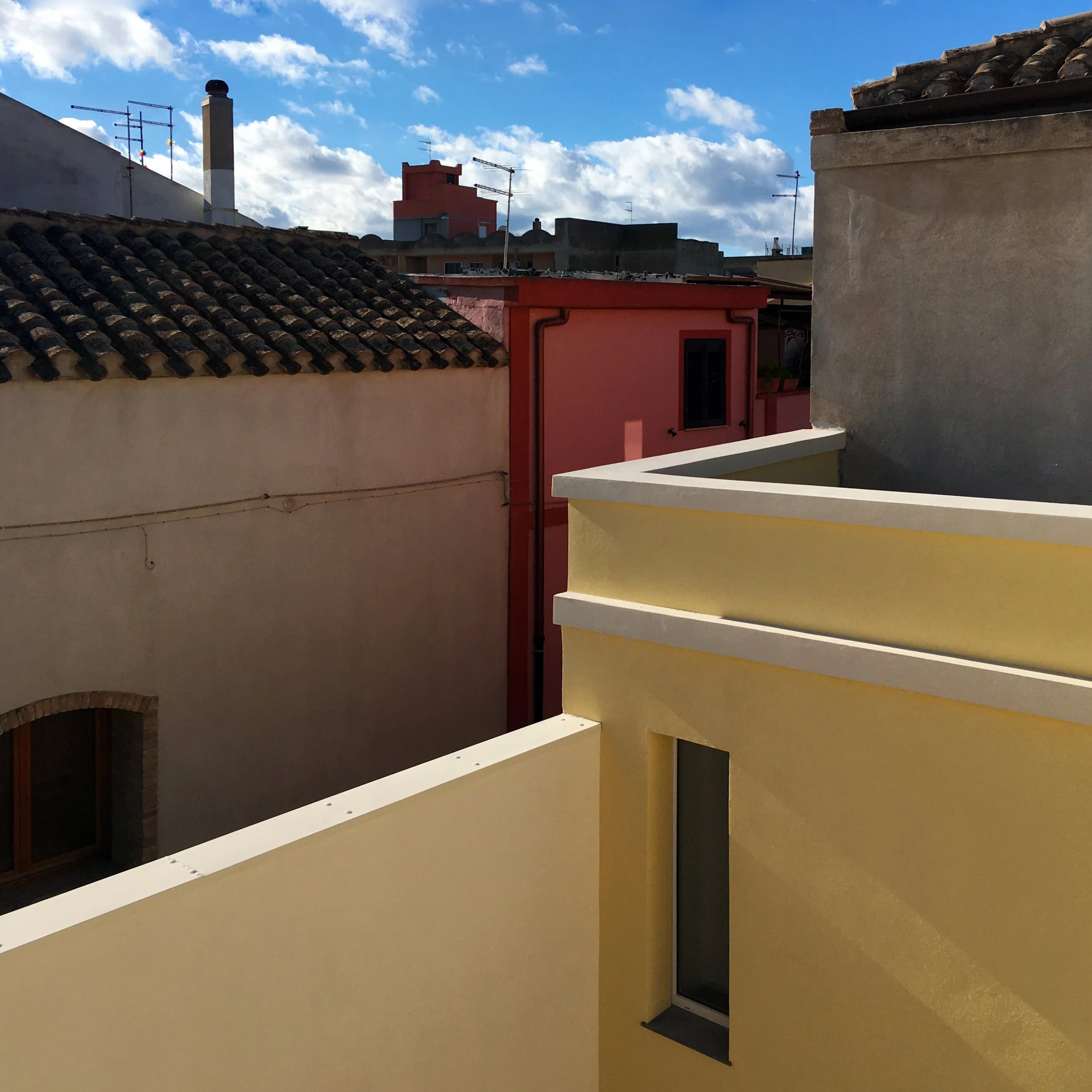 Vista dalla terrazza della casa campidanese restaurata con il volume dello studio ripulito dalle superfetazioni e i tetti del centro storico di Quartucciu sullo sfondo