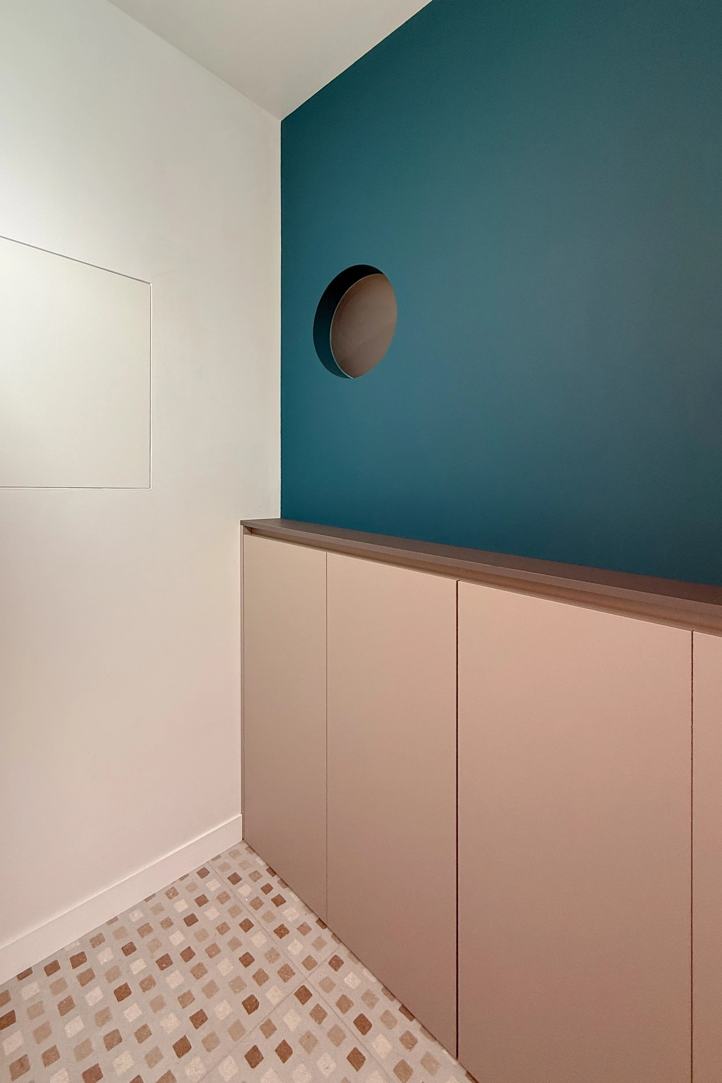 Dettaglio dell'ingresso, con l'armadio a incasso nel setto blu-petrolio e pavimento in gres porcellanato della serie Duo di Ceramica Sant'Agostino, Farina Loft, Cagliari