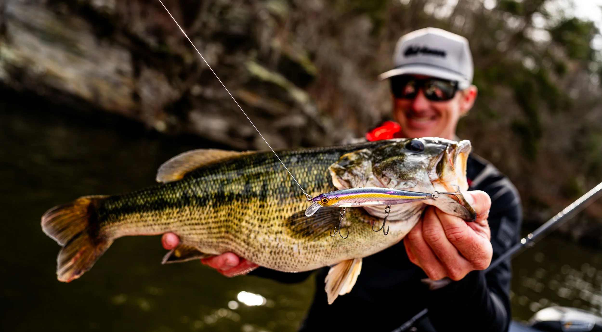 man with bass and rapala lure