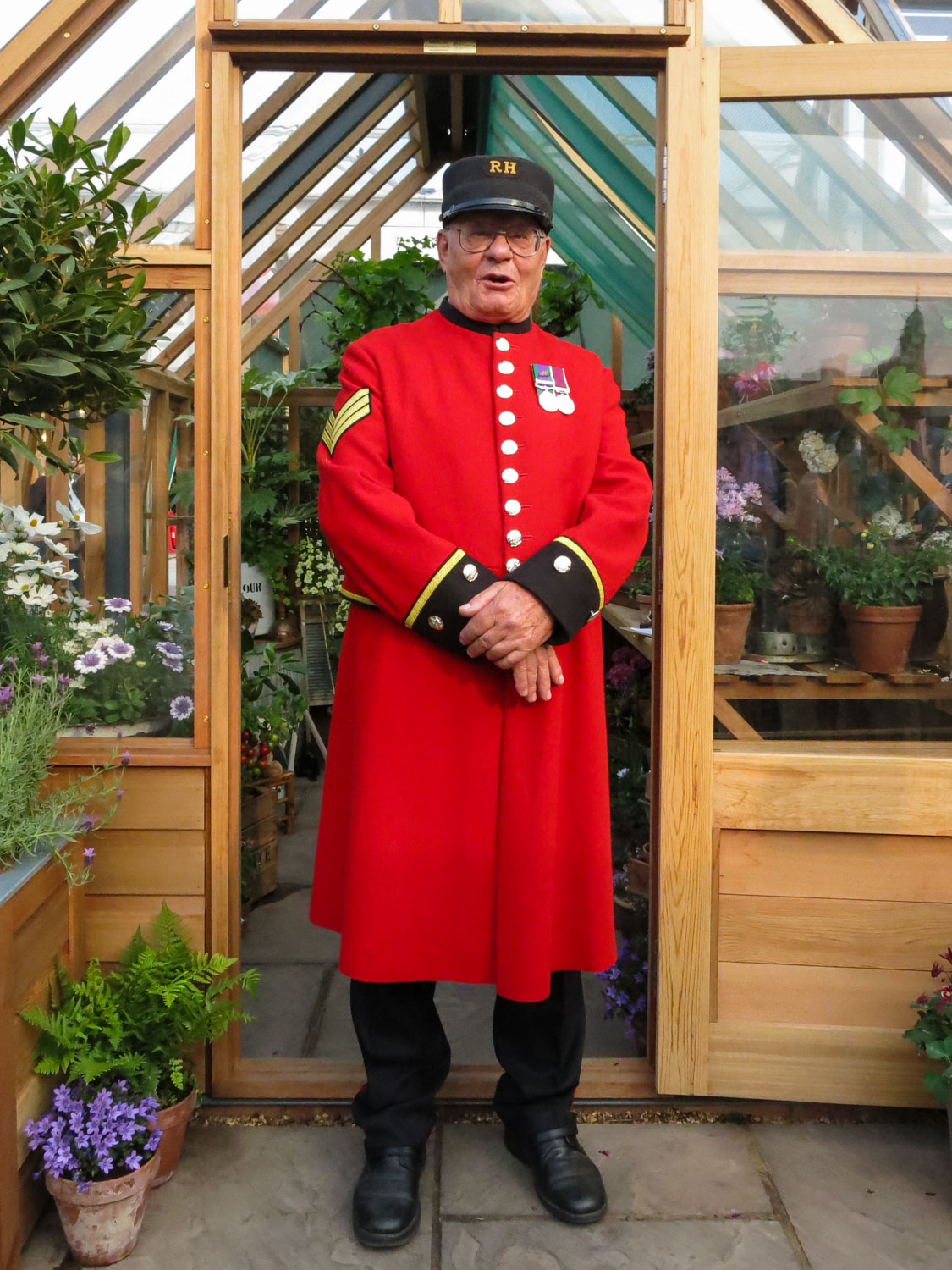 Chelsea Pensioner in front of the Gabriel Ash Hyde Hall Greenhouse. RHS Chelsea Flower Sho