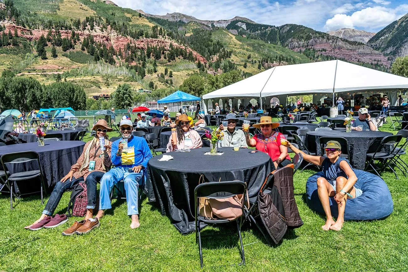 Guests relaxing together in the Telluride Jazz Festival VIP Area with comfortable seating, mountain views, and an exclusive festival experience.
