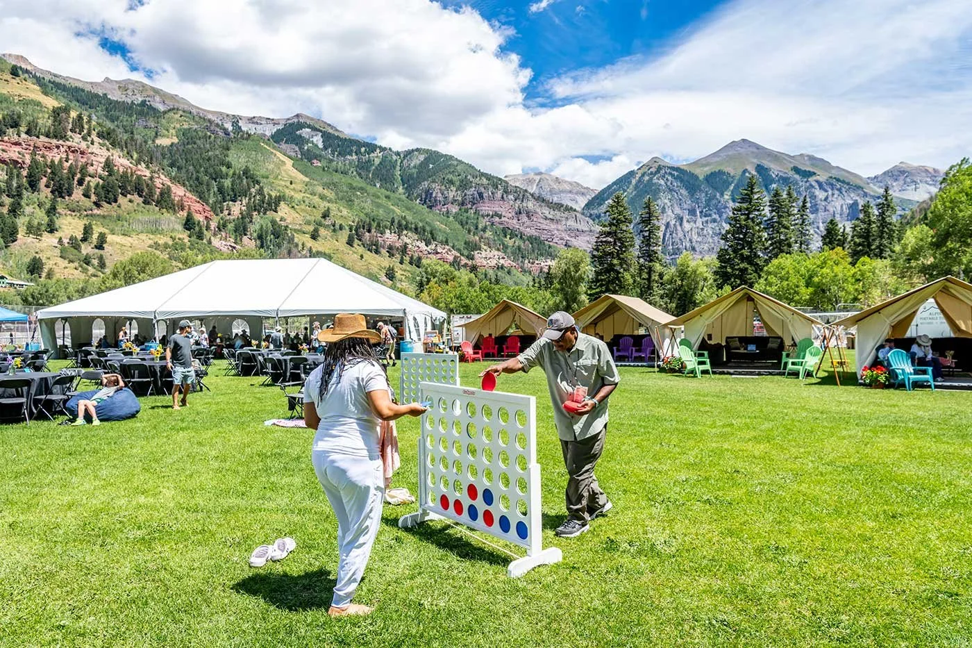 Friends playing a yard game together in the Telluride Jazz Festival VIP Area with relaxed seating, mountain views, and an elevated festival experience.