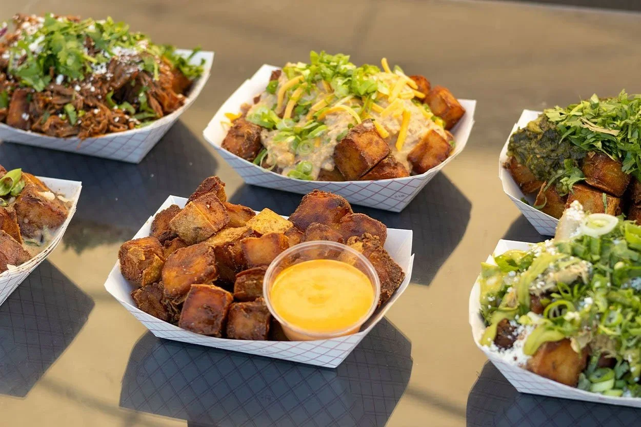 Tot Box makes house-made mashed potato tots, double baked and fried fresh, topped with scratch-made ingredients. Offering gluten-free, vegan, and vegetarian options with a team built on friendship, smiles, and good vibes.
