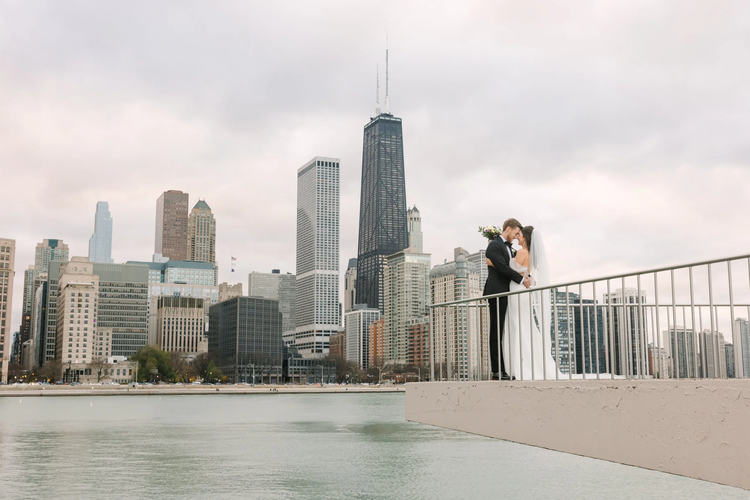 Dejanae Events couple standing on the balcony of the Adler Planetarium Chicago taking wedding photographs. This is one of the most popular wedding photography locations for engagement photos and wedding day photos.