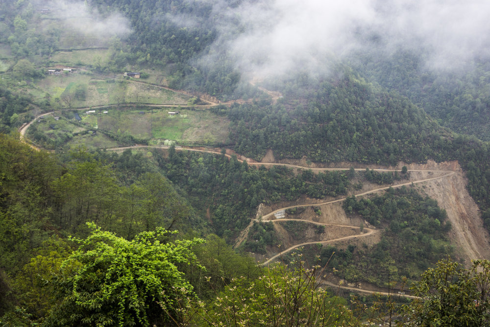 A road cuts through hills, near Bingzhongluo, Yunnan.