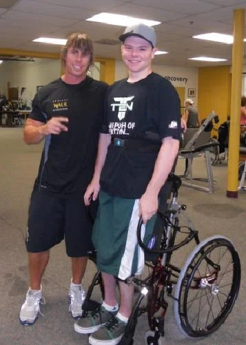 Joey (in a standing wheelchair) with his trainer, David.