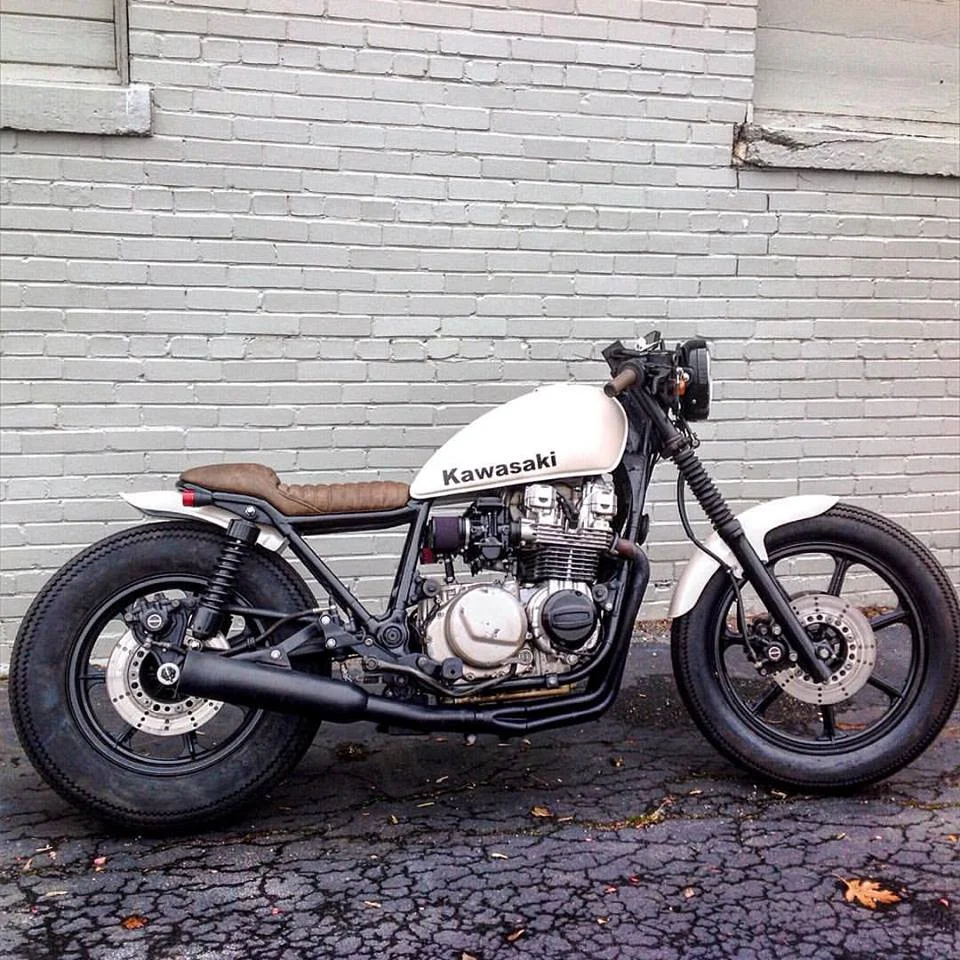 K awasaki Spectre caferacer project for @melizabeth3 completed and running oh so scary fast. Pearl white by First Place Finishes and super comfy seat and grip covers by @countyseats. This motorcycle got a tail chop, custom wireharness made in-house at Broken Sprocket Garage, new clubman handlebars , modified hand and foot controls, F irestone Deluxe Champion tires, carburetors r ebuild and rejetted and a fresh coating of black.