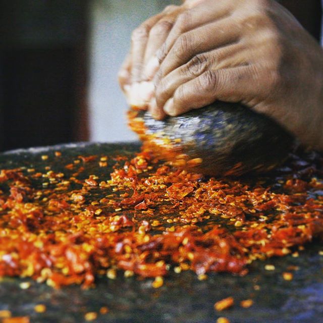 Spices of Nepal. Grinding red chili by hand with a round stone on the surface of a big and heavy flat stone. #chili #spice #flavour #red #chili #veg #vegi #foodie #spicy #traditional #culture #nepal #food #recipe #foodphotography  #flavoursofnepal