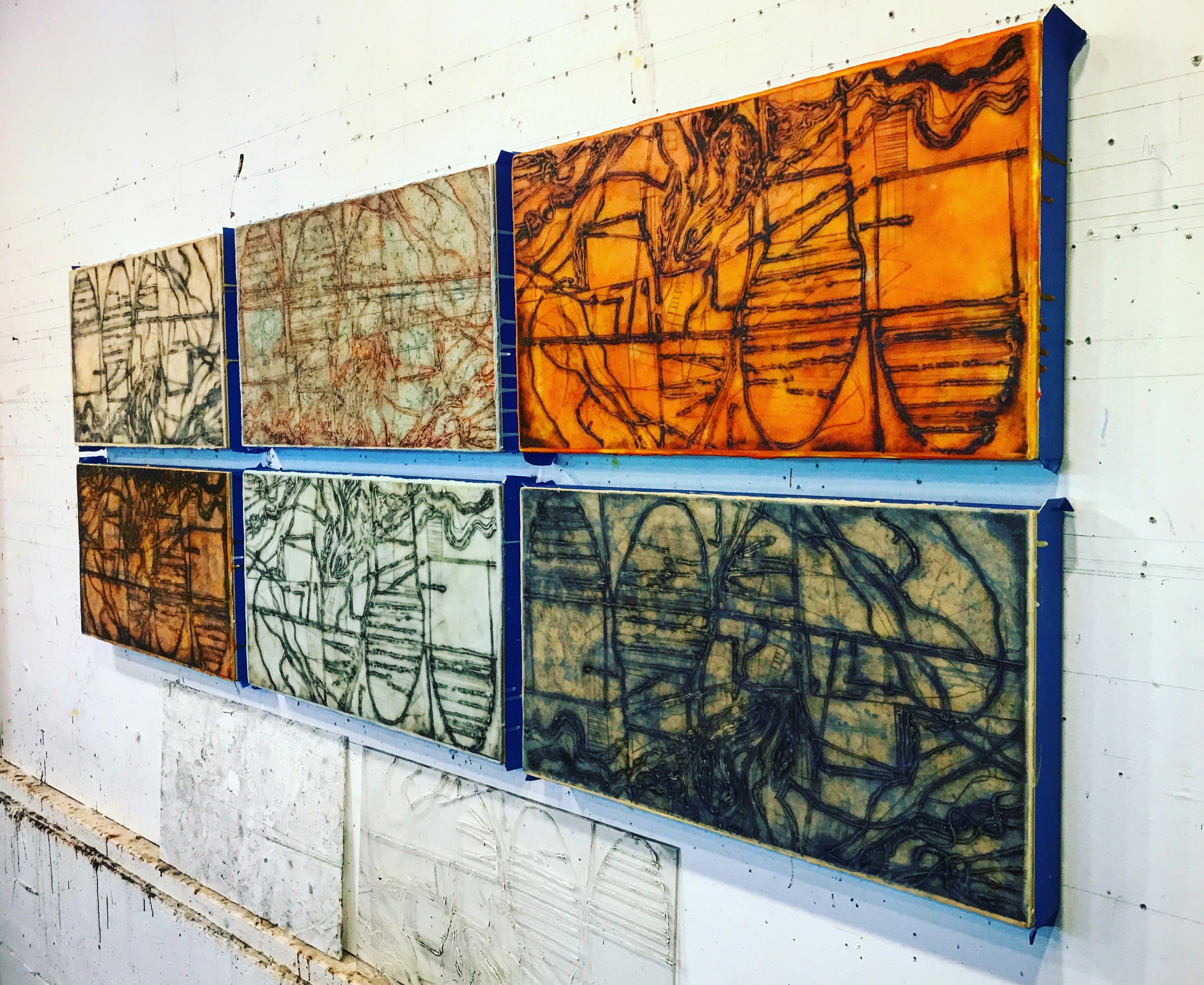 The mounted prints with a layer of wax over them and the printing plates they were created from.
