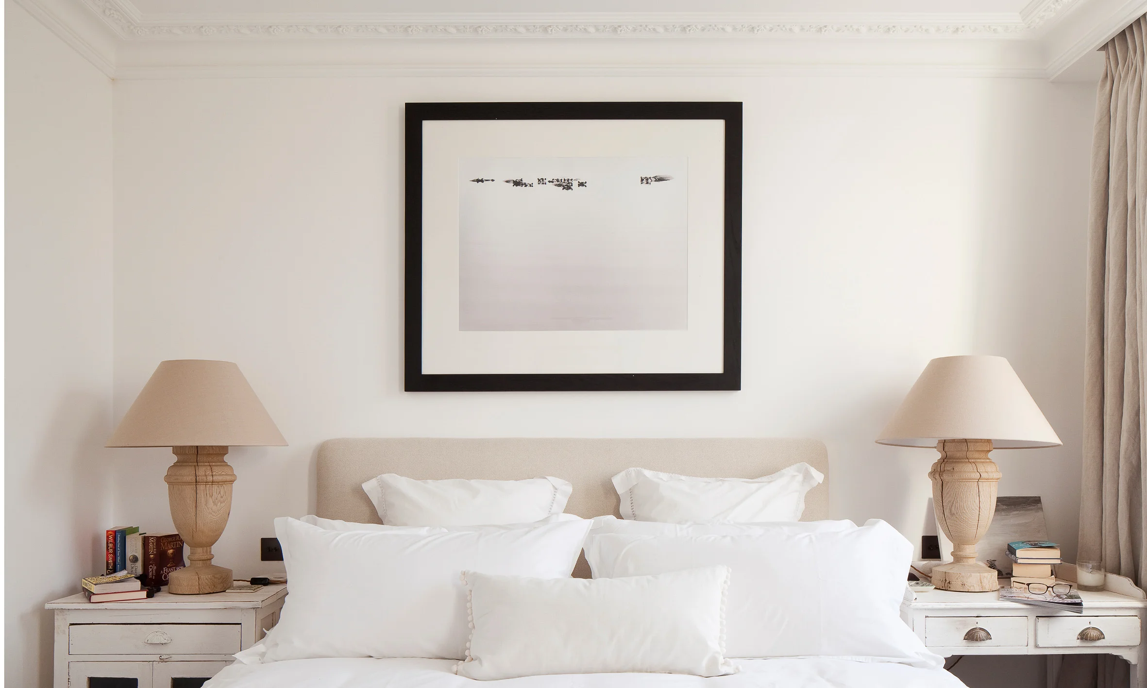 Perfectly symmetrical master bedroom. Luxuary plump pillows cover the bed with detailed architrave surrounding the room.