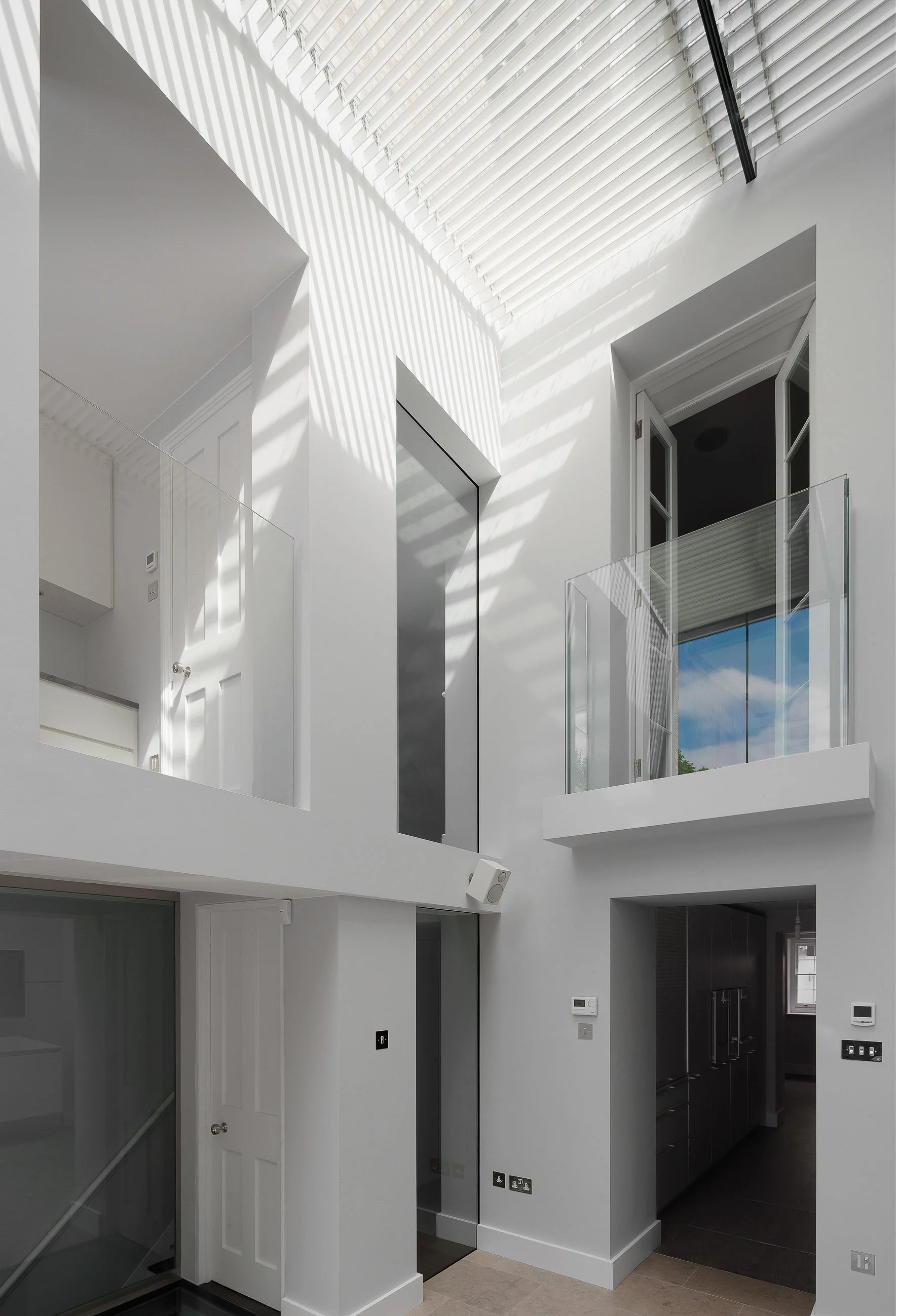 The double height living space with modern glass balustrades. The louversin the ceiling create the most wonderful shadows.