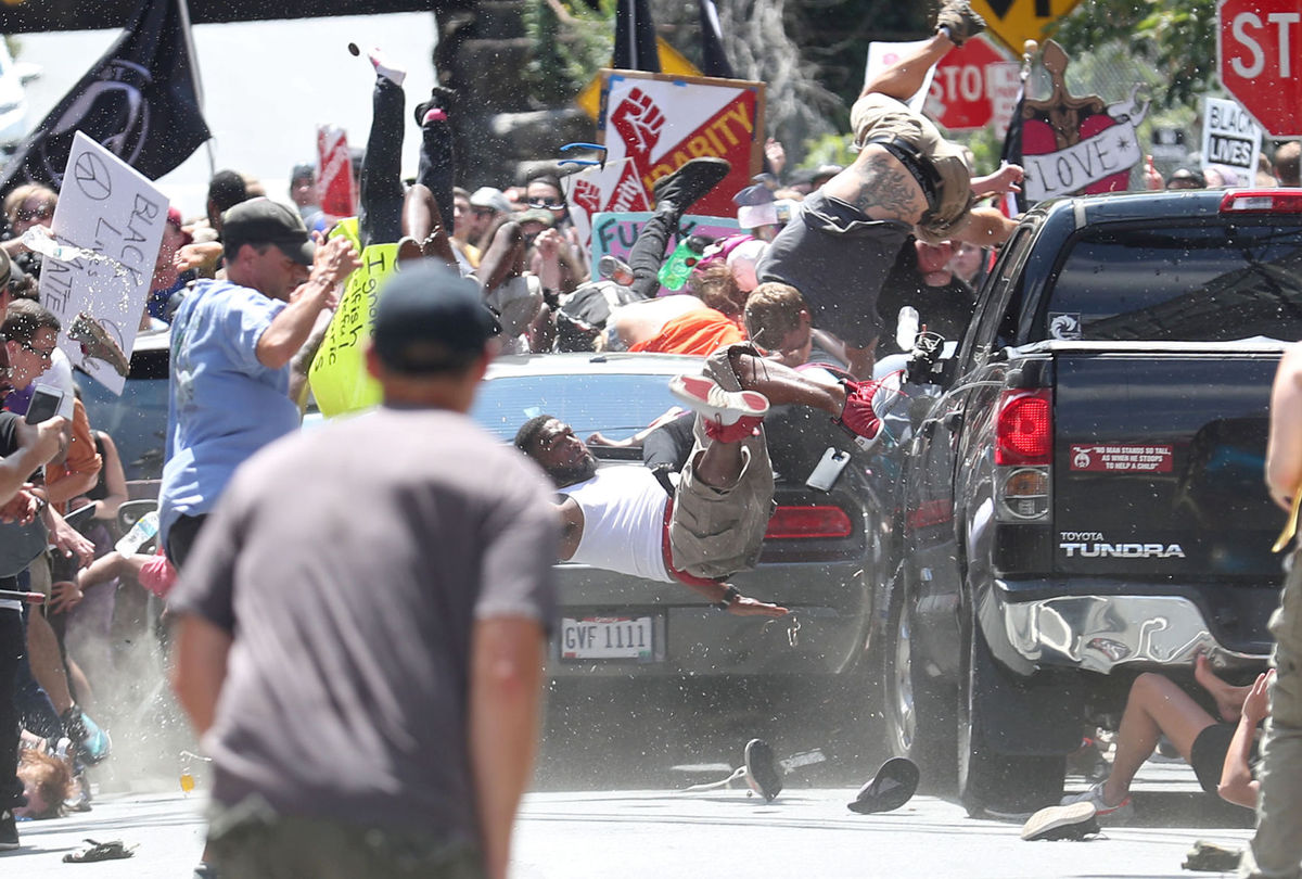 The black Challenger that would take the life of Heather Heyer narrowly misses law students Leanne Chia and Elizabeth Sines. Photo courtesy Daily Progress.