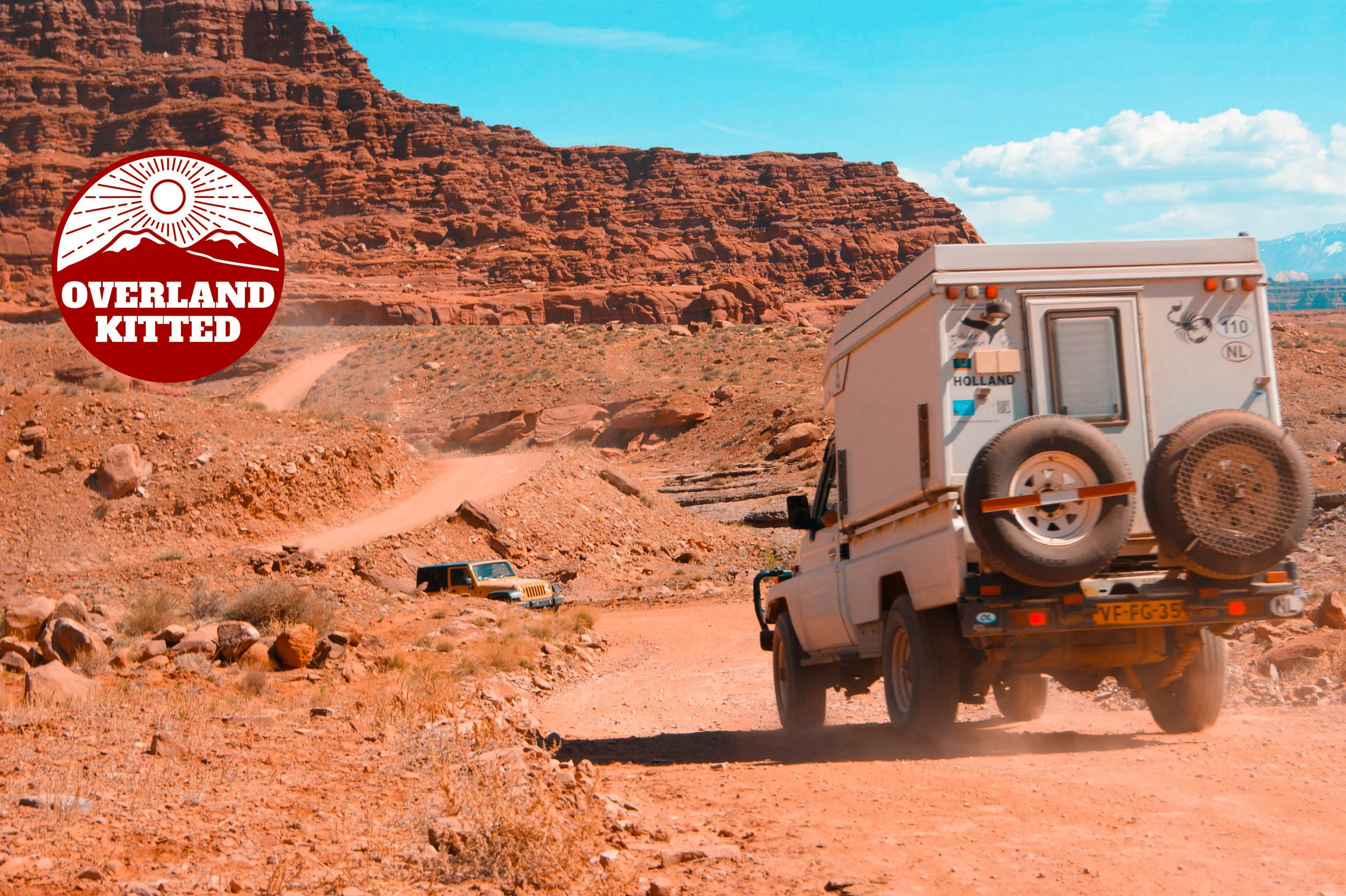 An early model Toyota Hilux passing a late model Jeep JK on the trail during a multi-continental overland adventure.
