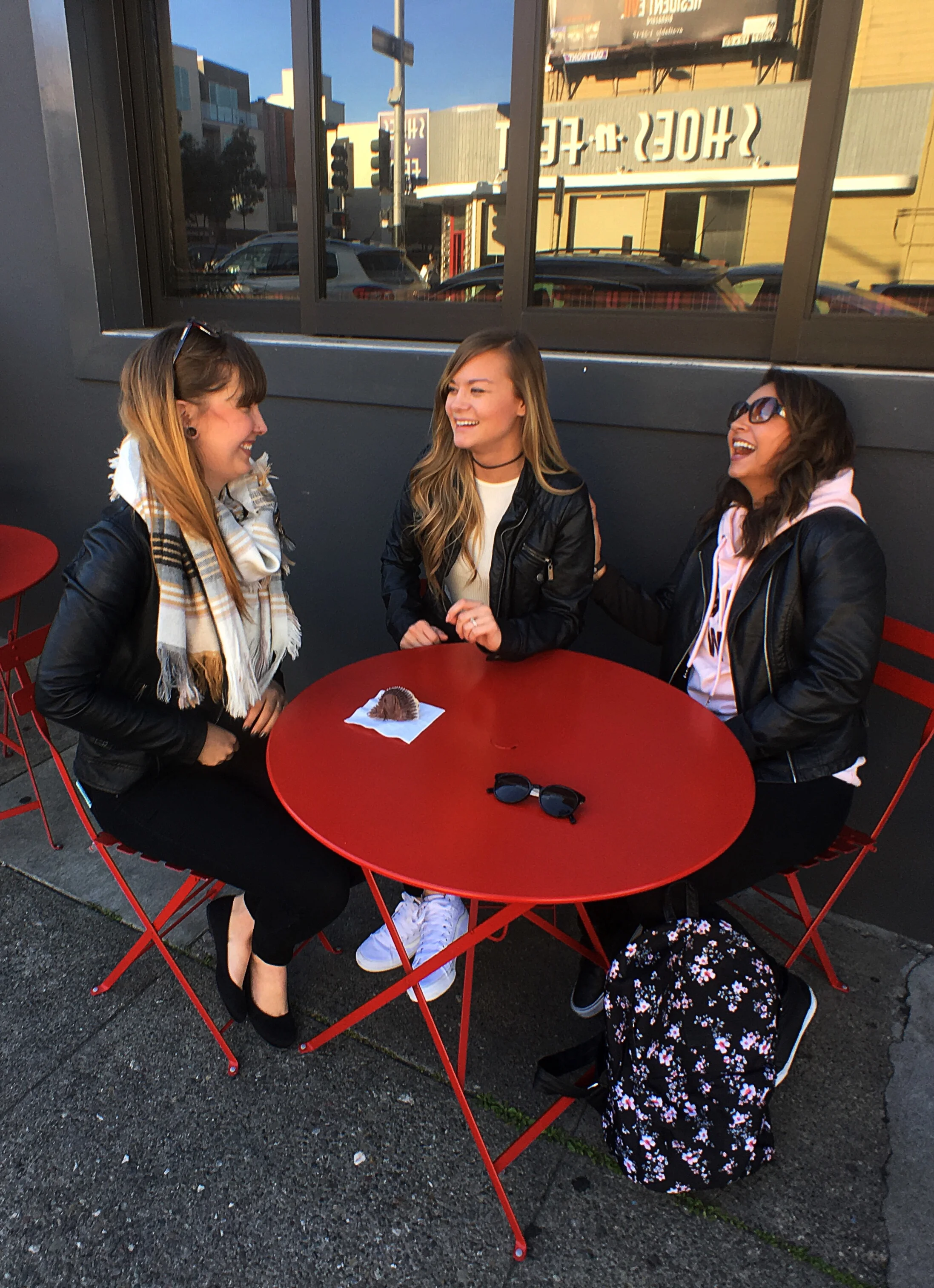 Gal Pals enjoying Kara's cupcakes in San Francisco, California. Red metal picnic table 