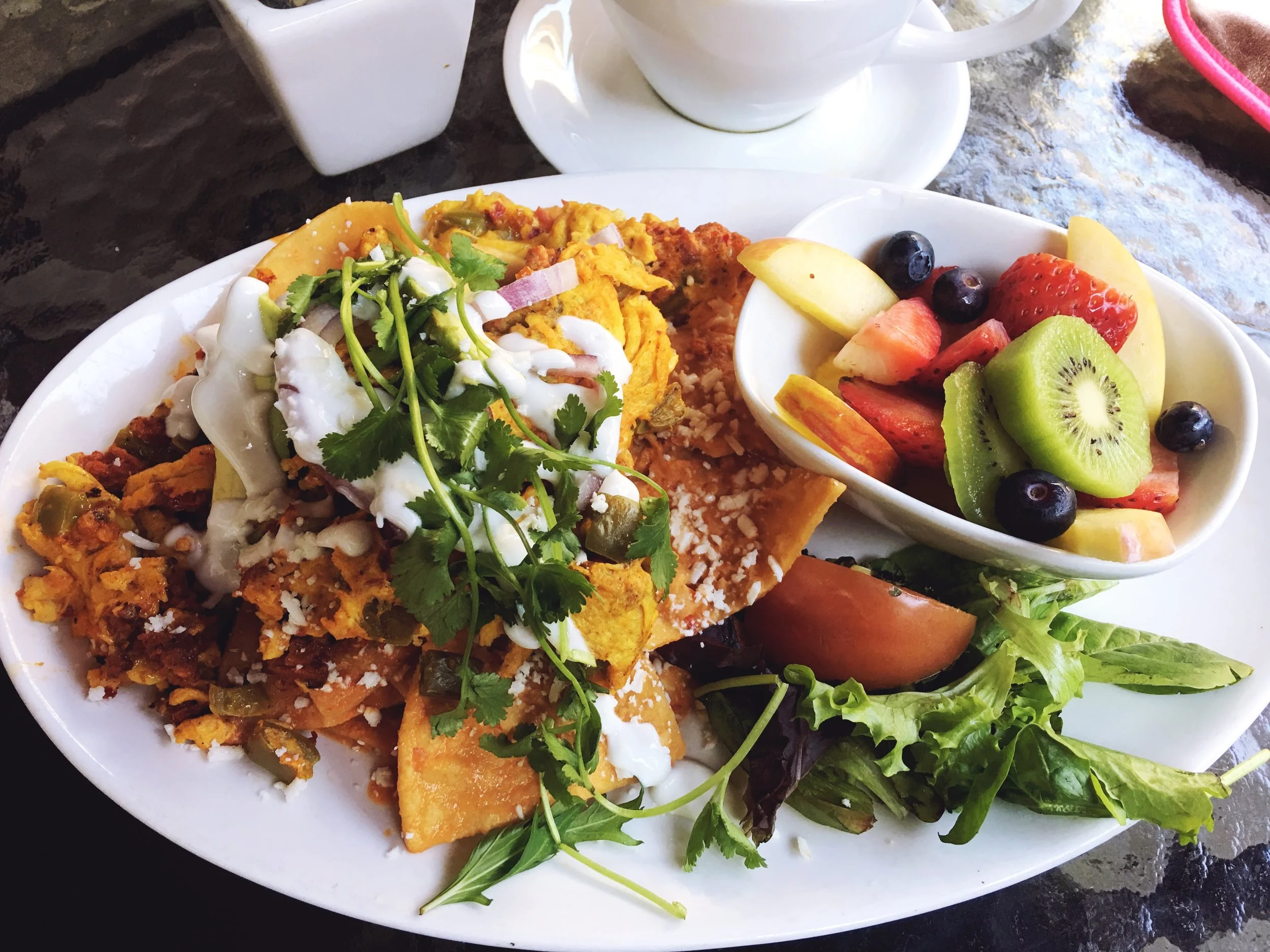Chorizo and Chilaquiles (fried tortillas) and a side of fruit from La Mo Cafe 