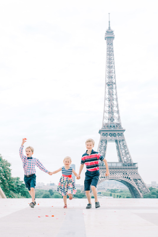 paris photographer - family photo shoot with kids having fun at the Eiffel Tower in Paris