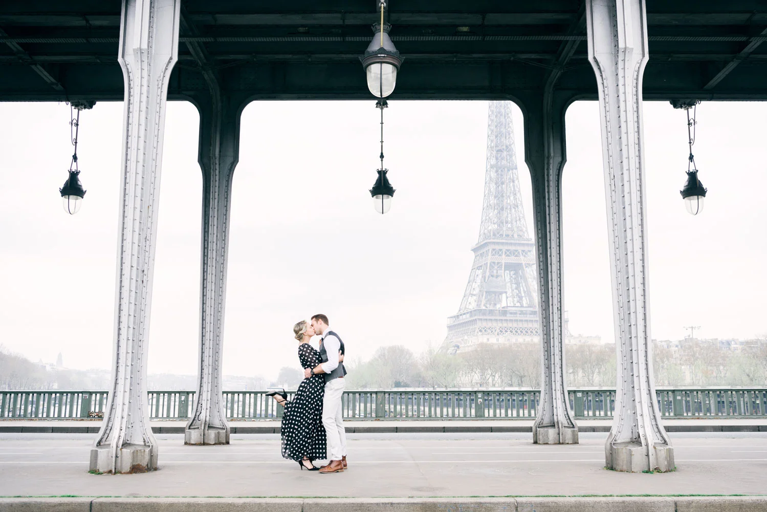 Paris Photographer - A couple kissing in front of the Eiffel Tower in Paris by Tim Moore