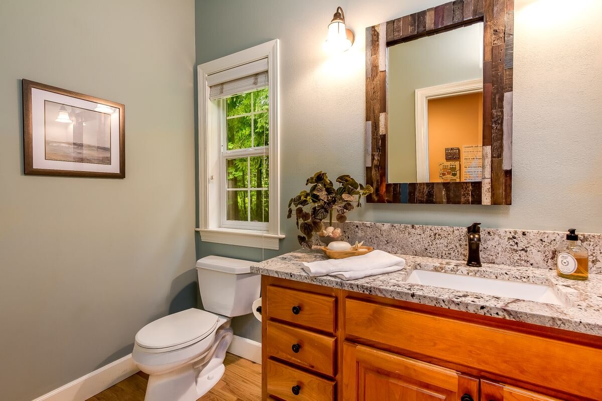  The powder room has hardwood floors, newer quartz counter, and is located off the great room next to the office. 