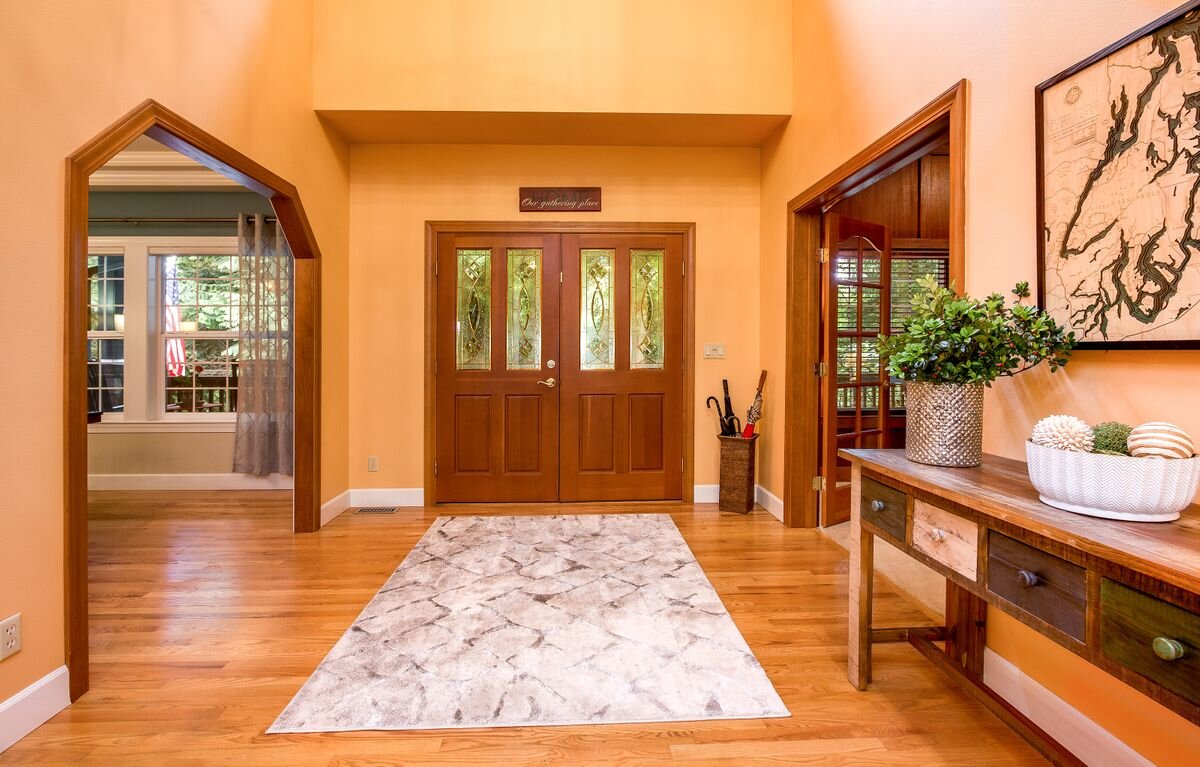  The solid wood front doors feature artisan glass windows and open to the generously proportioned foyer with a den/office to the right and a formal dining room to the left. Gleaming hardwoods lead throughout the main living areas. 