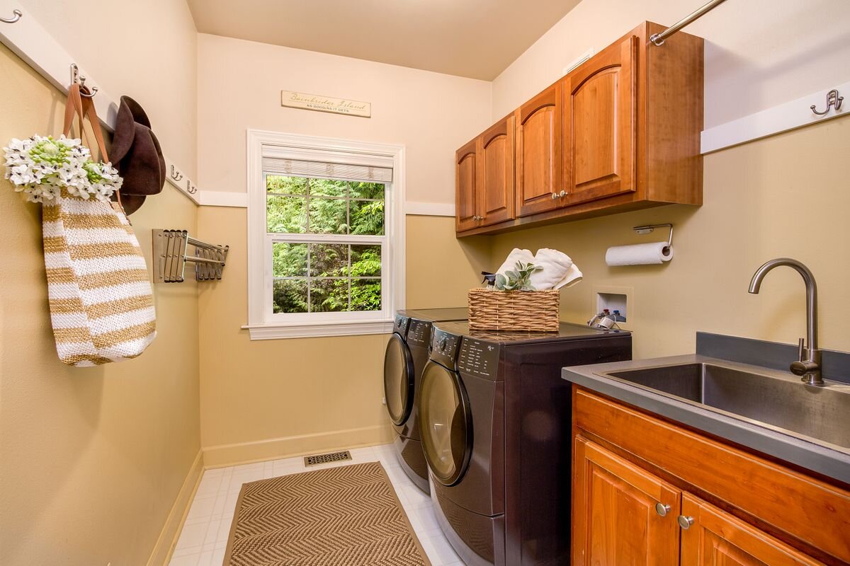  The laundry/mud room has lots of space for coats and boots and is conveniently located between the 3-car garage and kitchen. It has built-in cabinetry, a hanging rack, and a new stainless laundry sink. Not shown is the broom closet and large pantry 