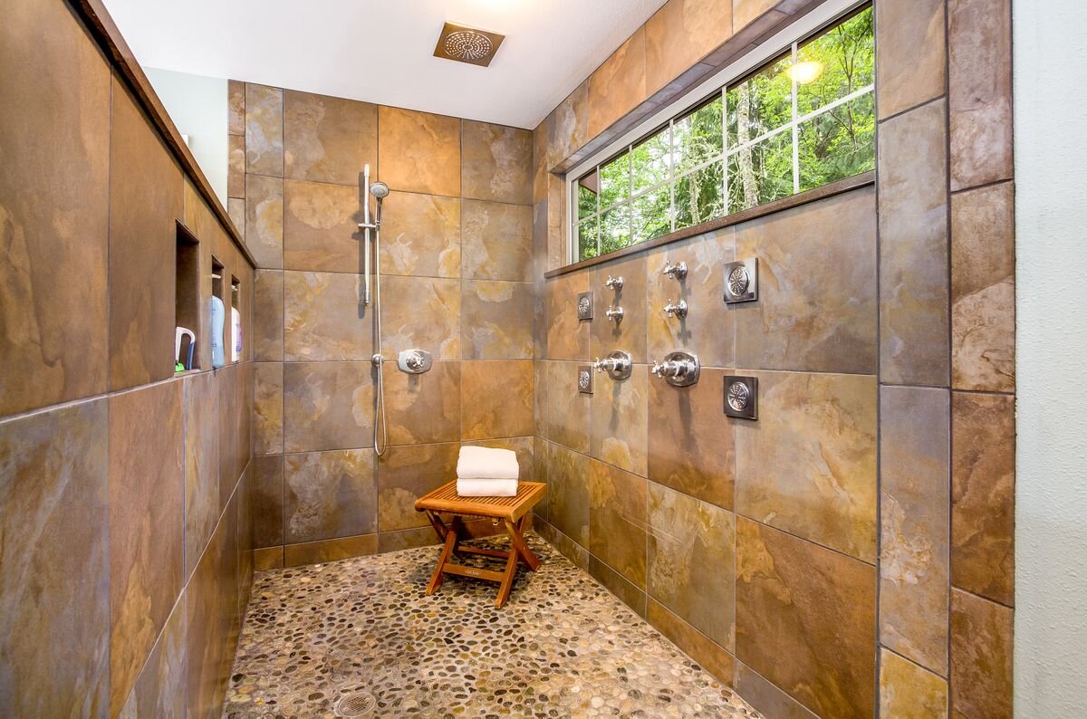  The master bath has been fully renovated and features a two-person shower with body spray jets, rain showerhead and natural stone floor. 