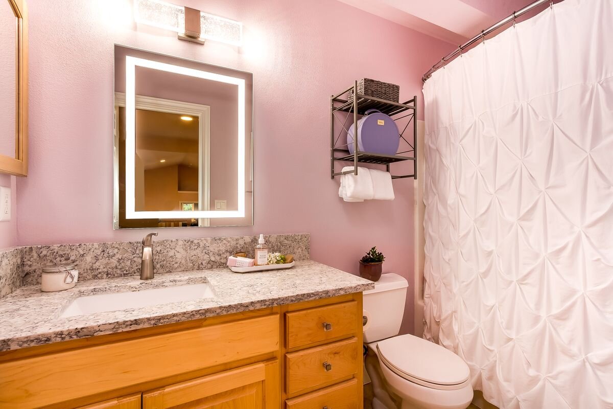 All bathrooms in the home have been updated—this bathroom is located off the 'homework nook' between two large bedrooms and features quartz countertops, undermount sink, new bath fixtures, light fixtures and lighted mirror. 