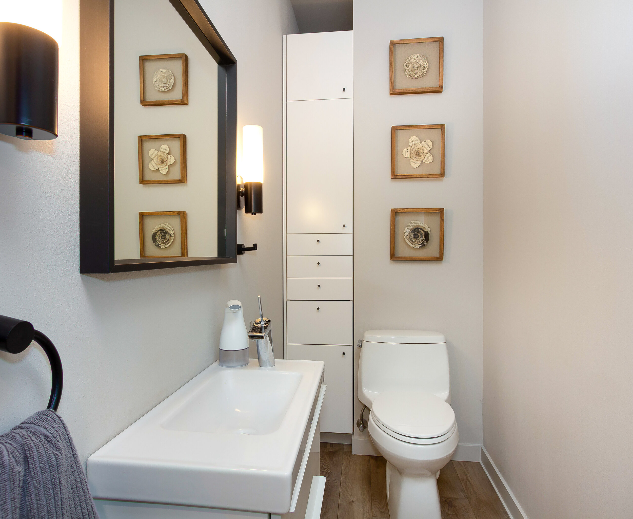 A half bath on the main floor makes use of chic, modern design and is perfect for company. 