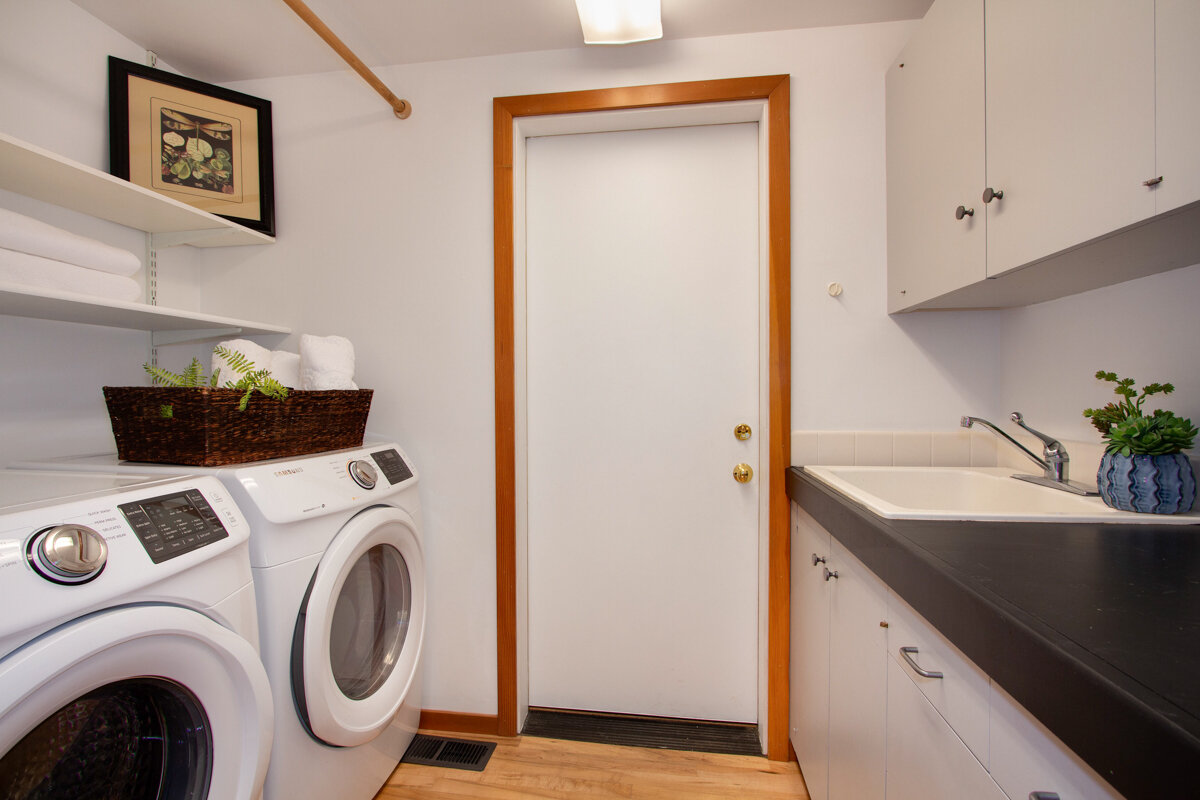 The generous laundry room is complete with plenty of storage, a sink, and a counter, perfect for folding your latest clean load. 