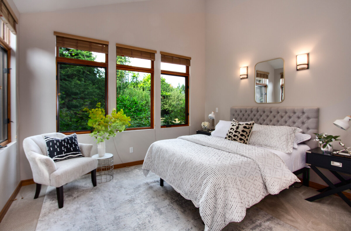 A comfortable master bedroom features high ceilings, which make it feel extra light, airy and spacious.