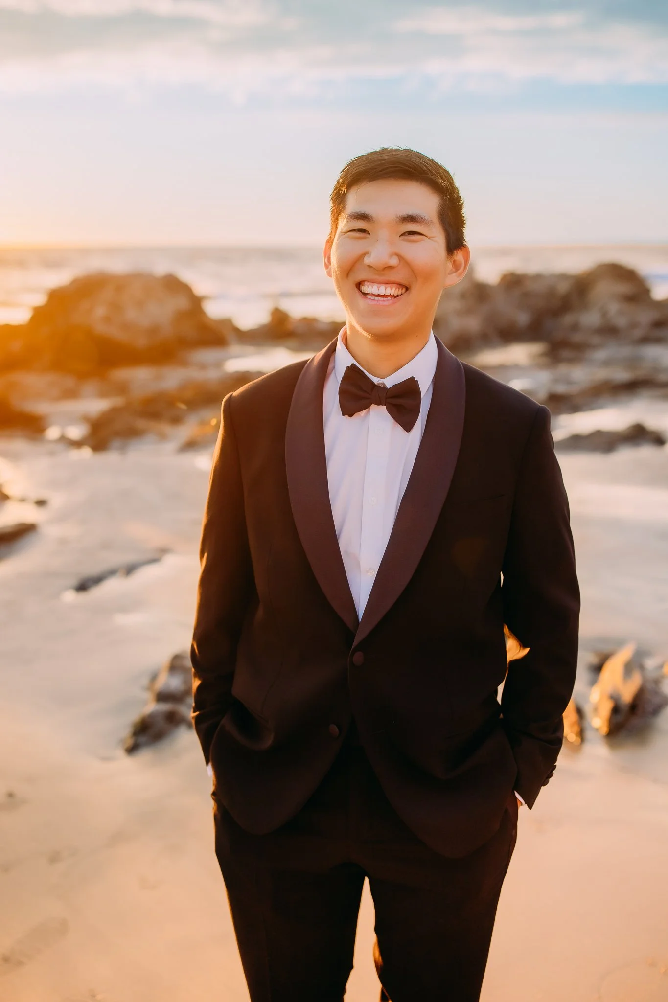 groom happily smiling during bridal portraits at Newport Beach, CA during a sunset beach shoot