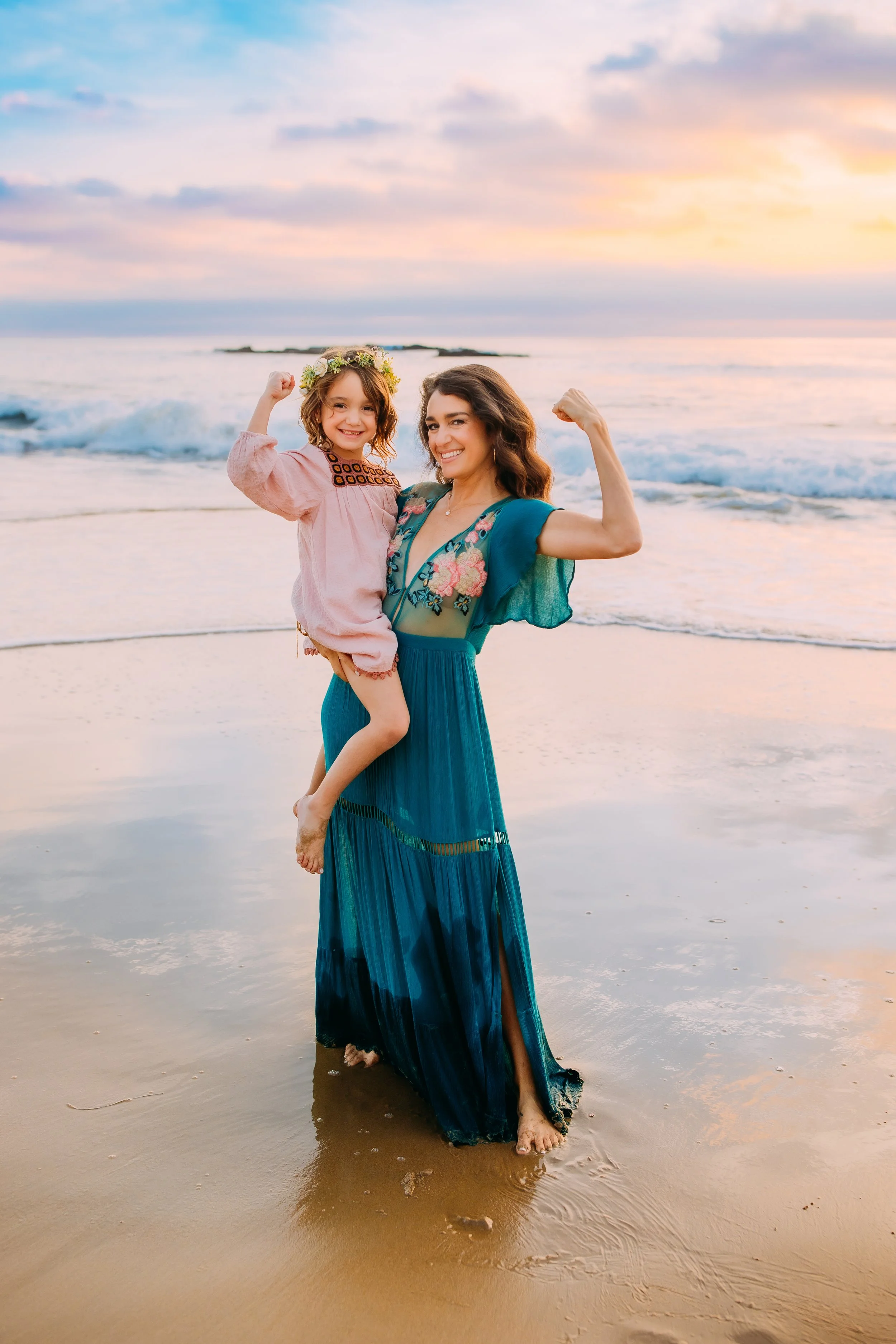mom and daughter showing their women power during their family photos in Newport Beach, California