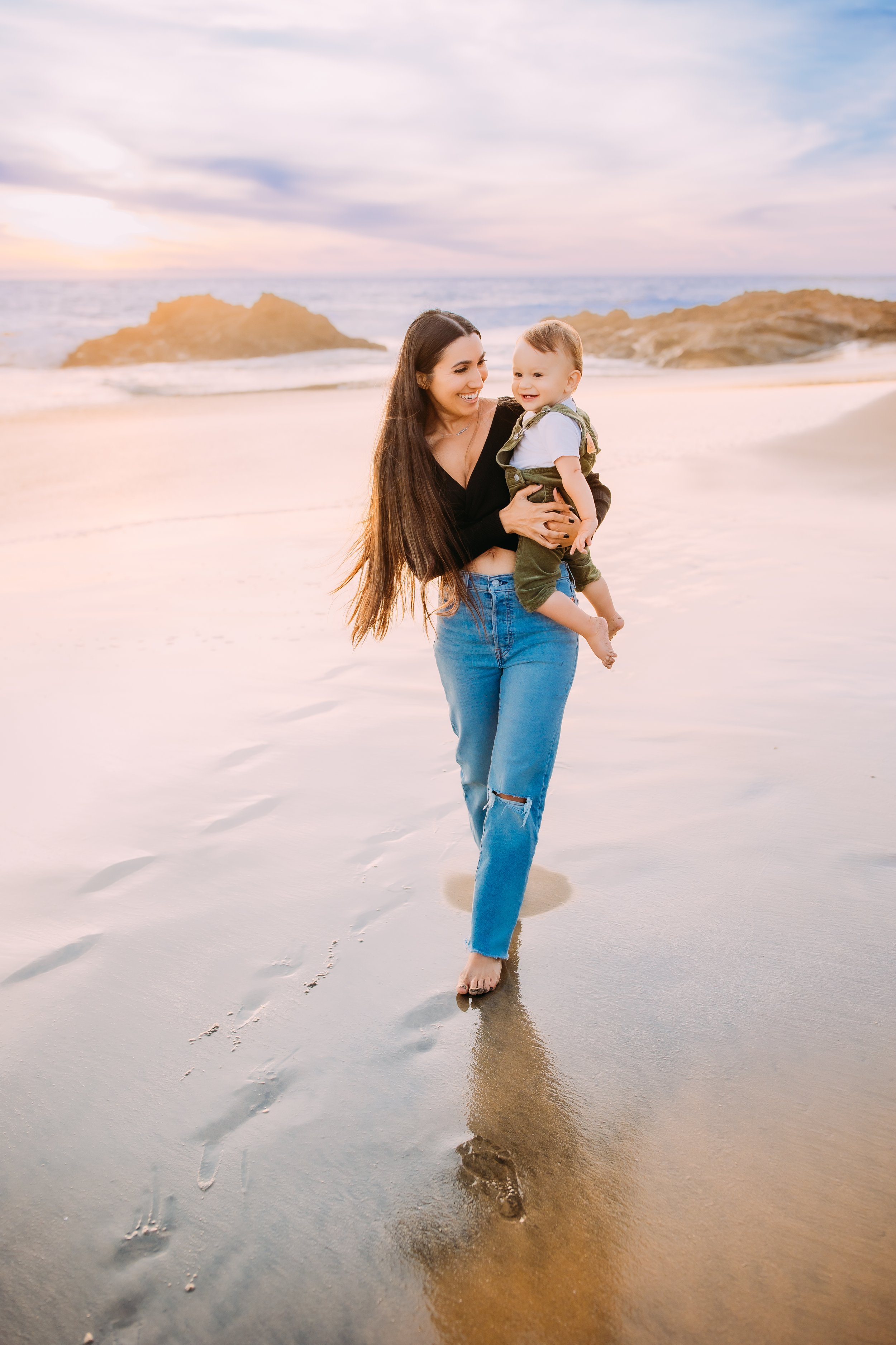 Mother holding her one-year-old son on the beach during a Newport Beach mommy and me photoshoot.