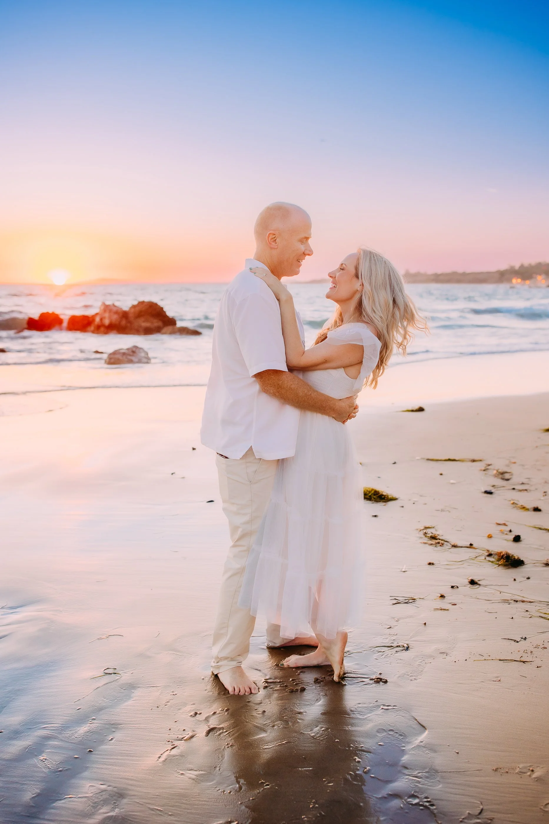 mom and dad sneaking in a solo picture during their family photoshoot in Newport Beach, California