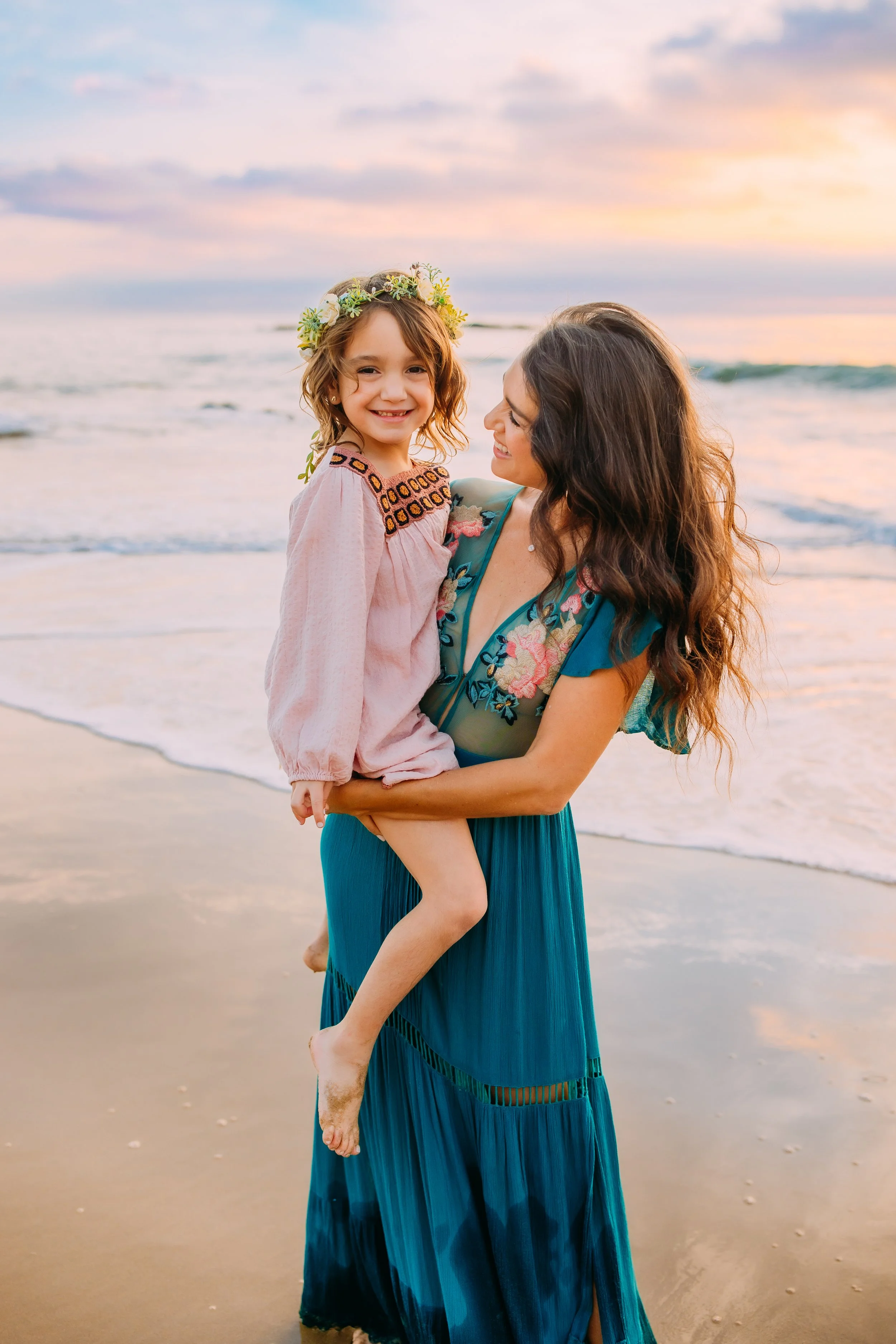 mom lovingly smiling at her daughter during their family photo session in Newport Beach, California