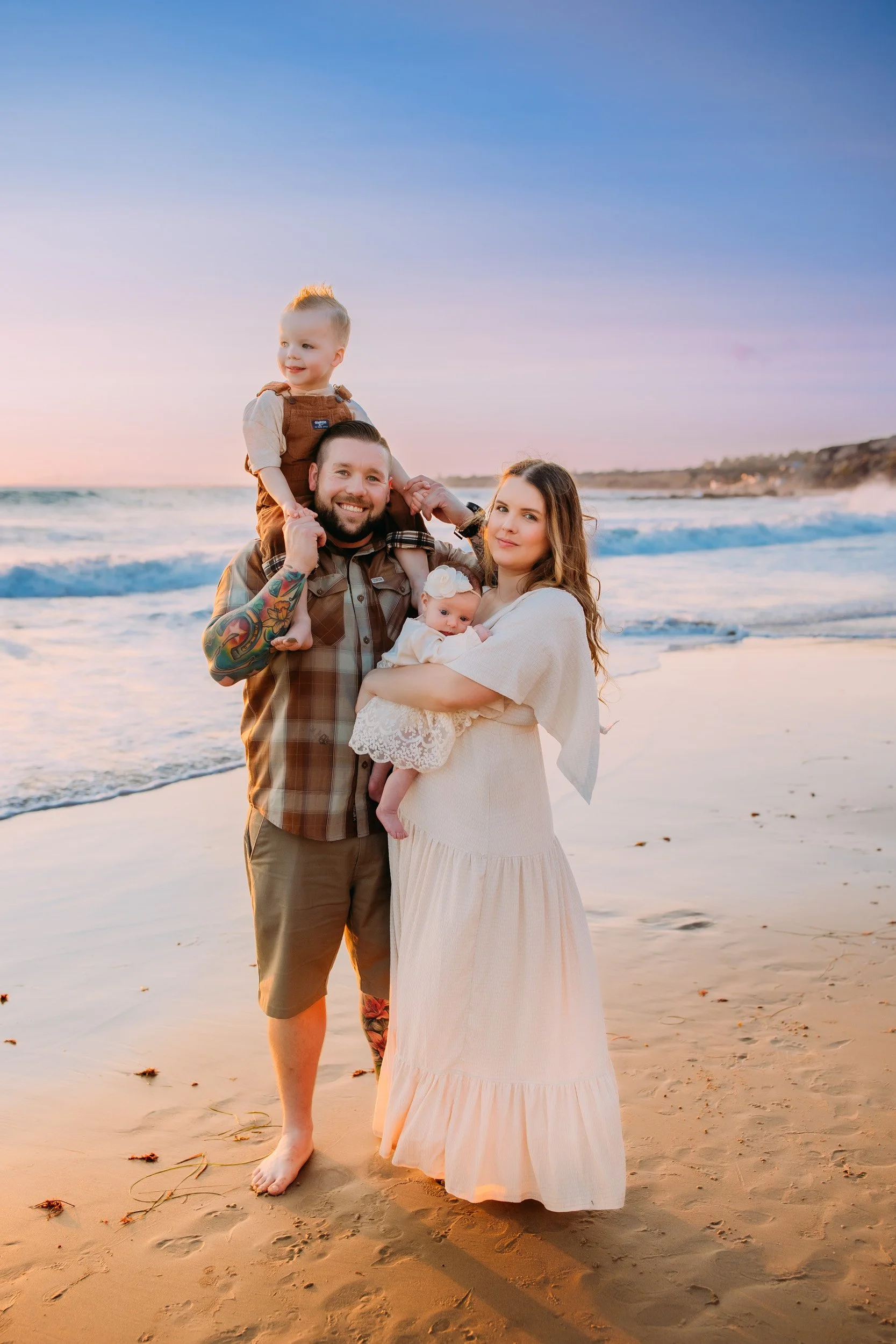 family posing for a portrait at sunset during their photo session in Newport Beach, CA