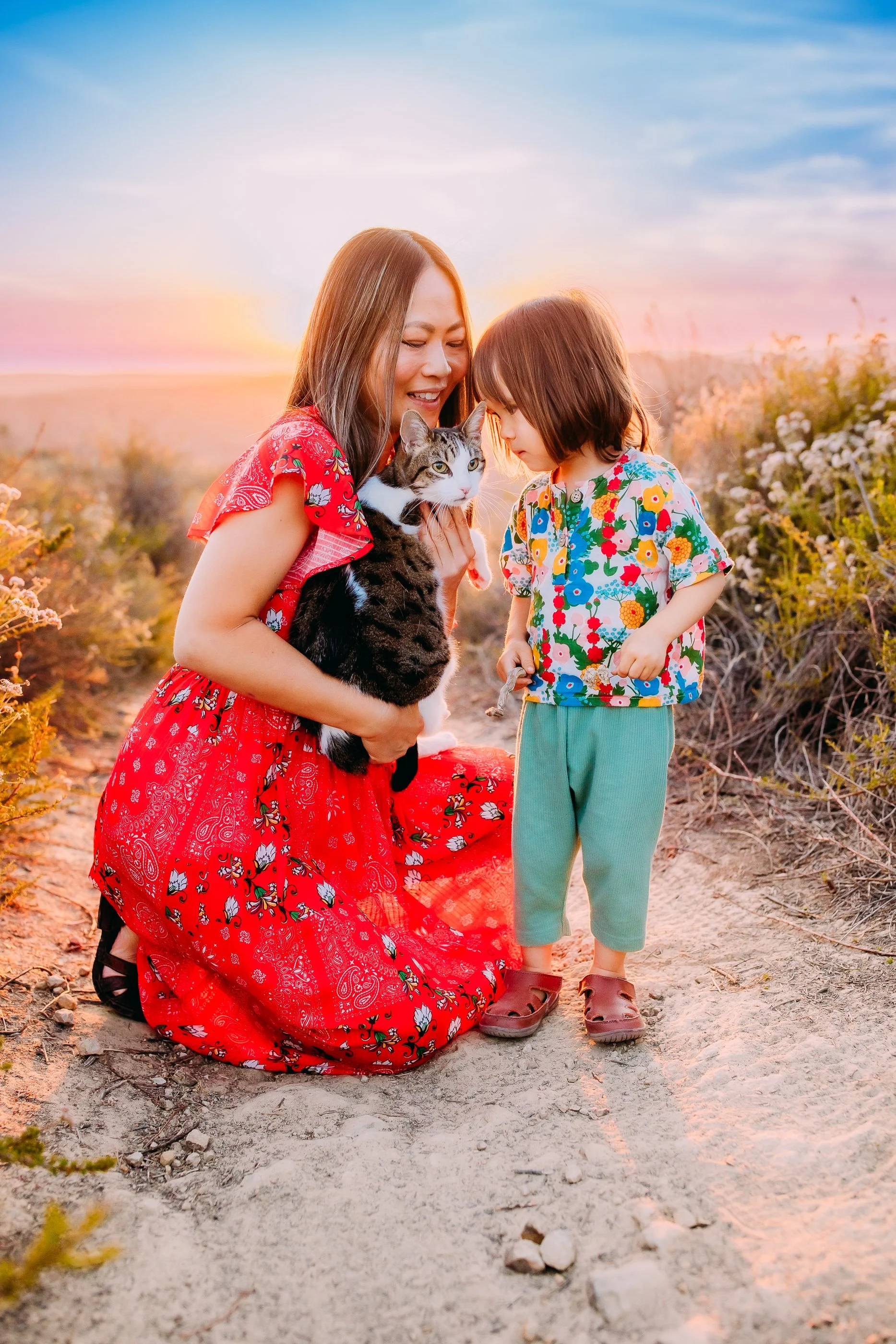 mom and son embracing their pet cat during their family photo session in the foothills of Laguna Beach, CA