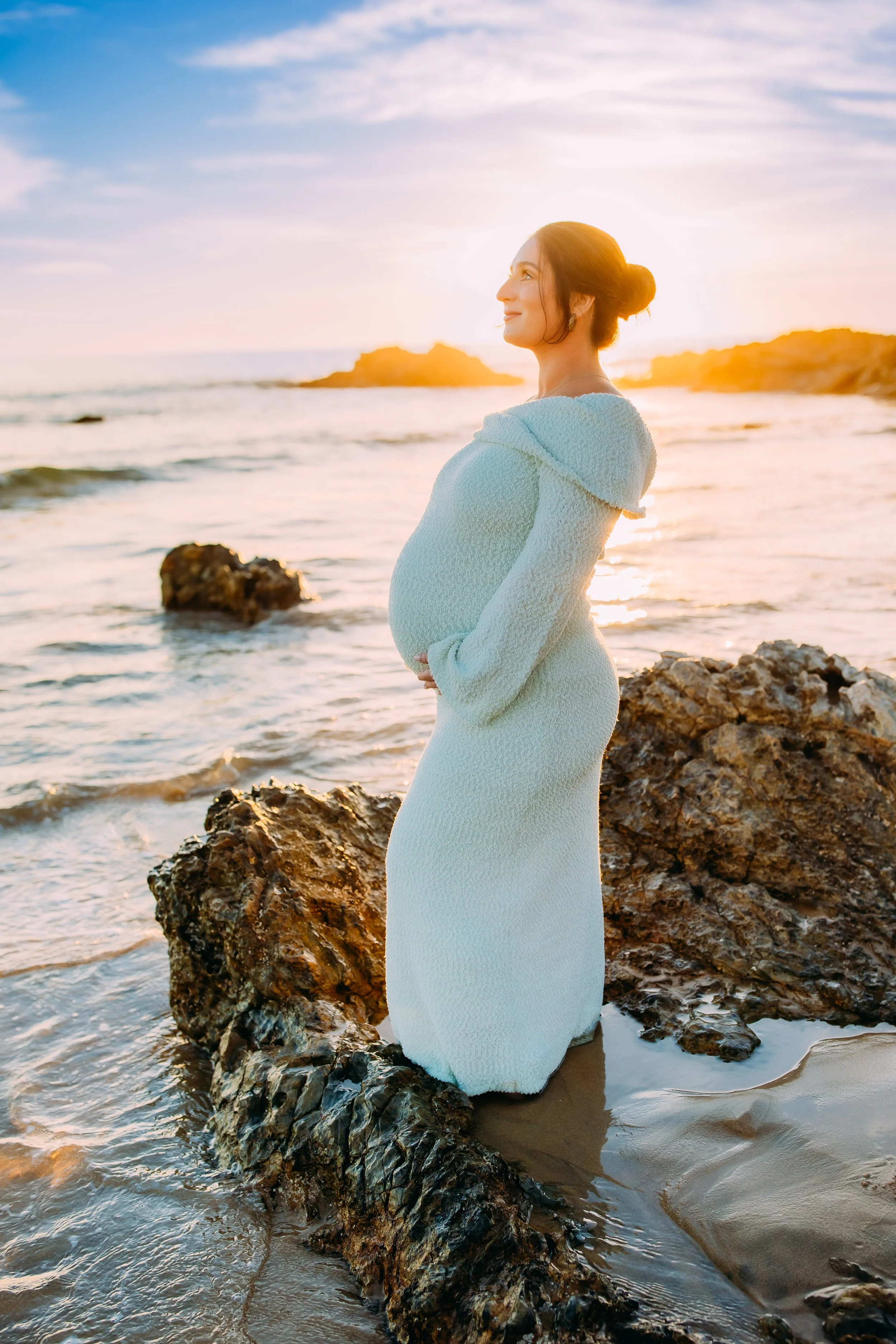 pregnant mom looking up into the sunset during her beach photoshoot in Newport Beach, Orange County, California