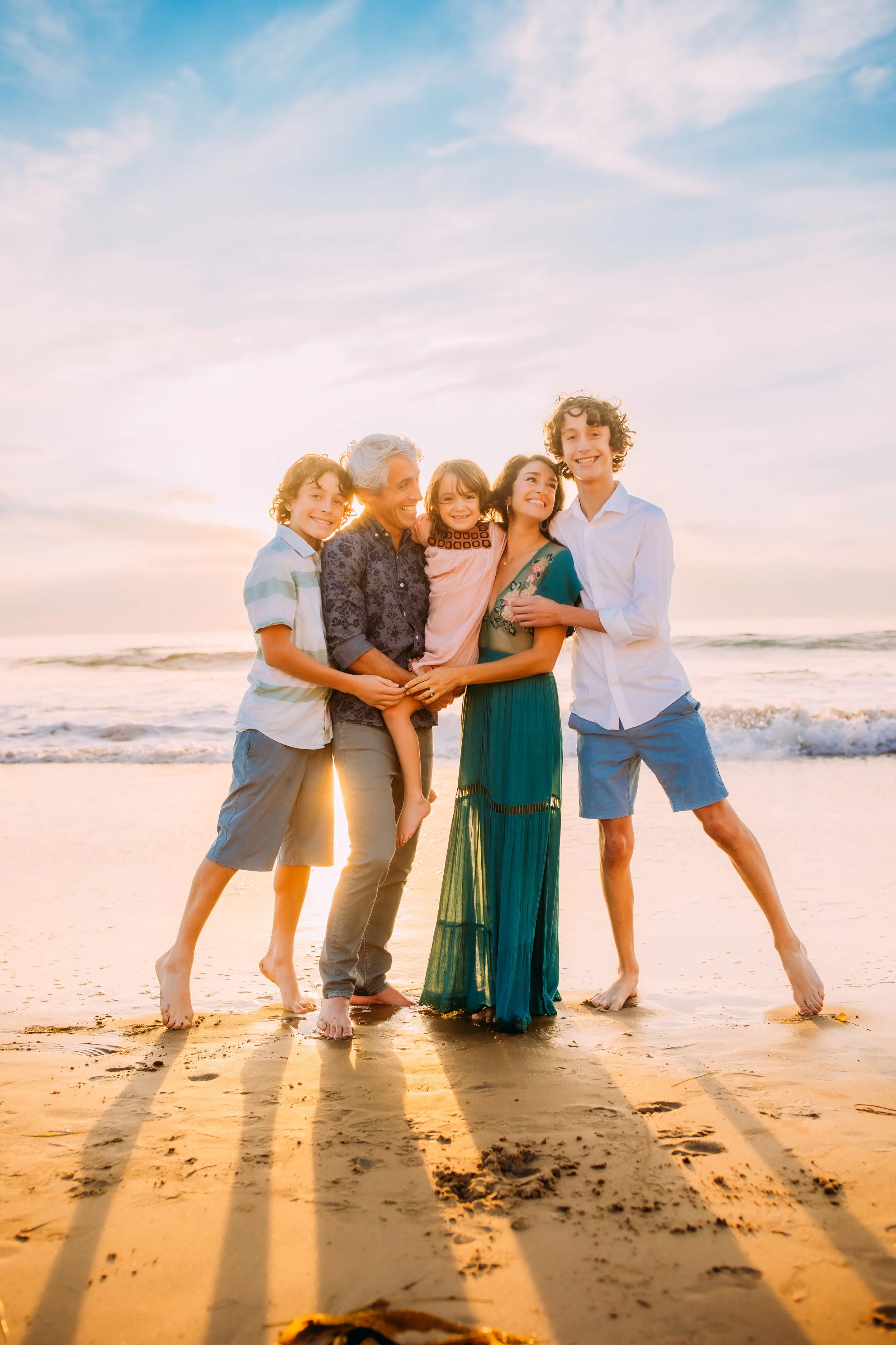 family happily smiling during their photo session at Newport Beach, California