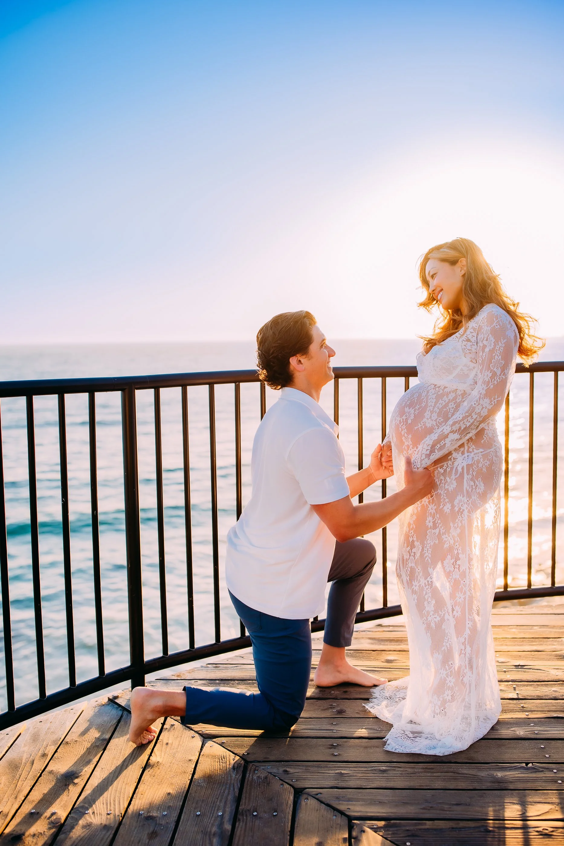 husband and pregnant wife recreate the scene where he first proposed to her during their maternity photo session in Laguna Beach, California