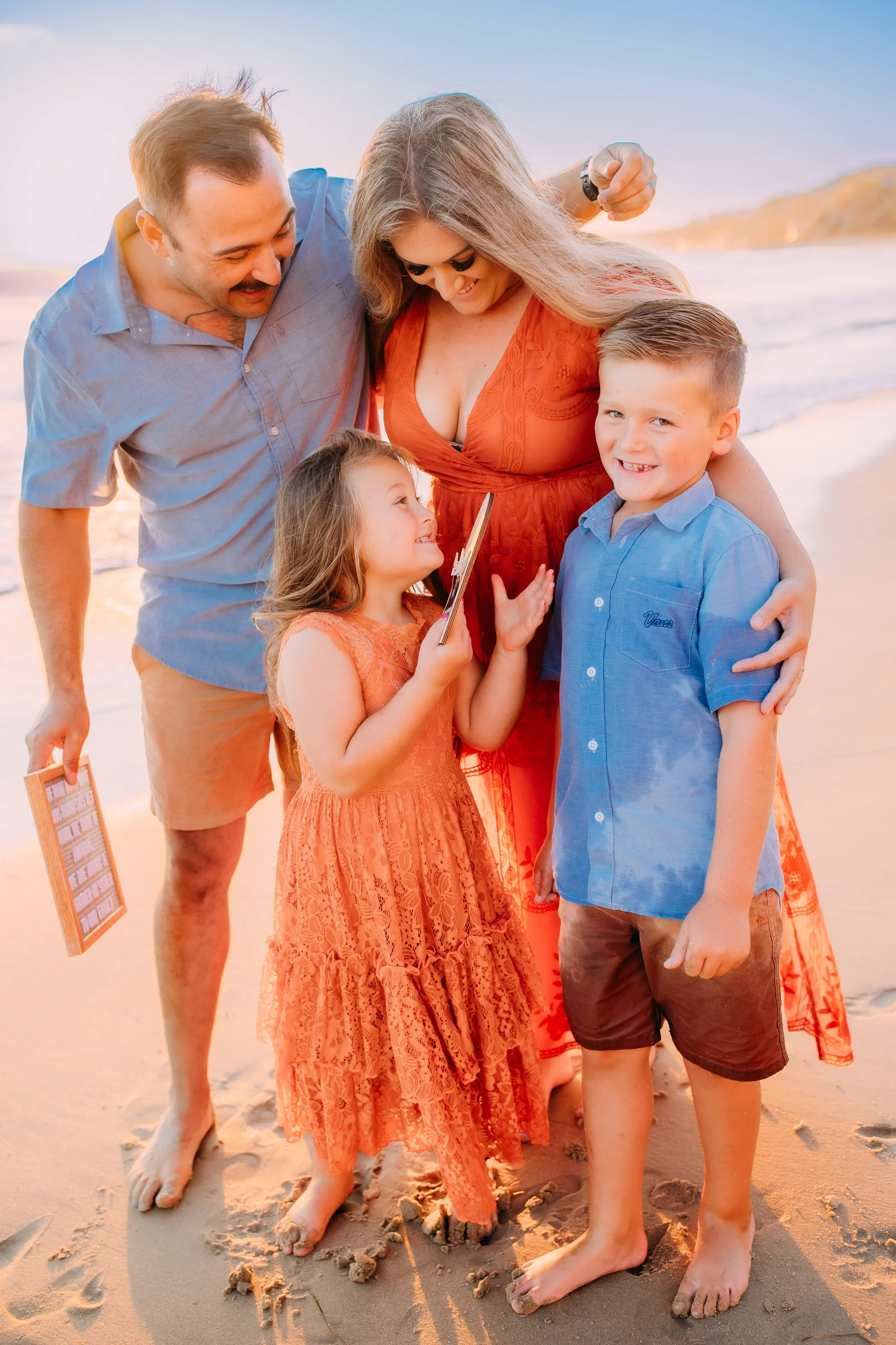 family all together while the siblings are overjoyed hearing the baby announcement that they are going to add a new baby to the family in Newport Beach, California