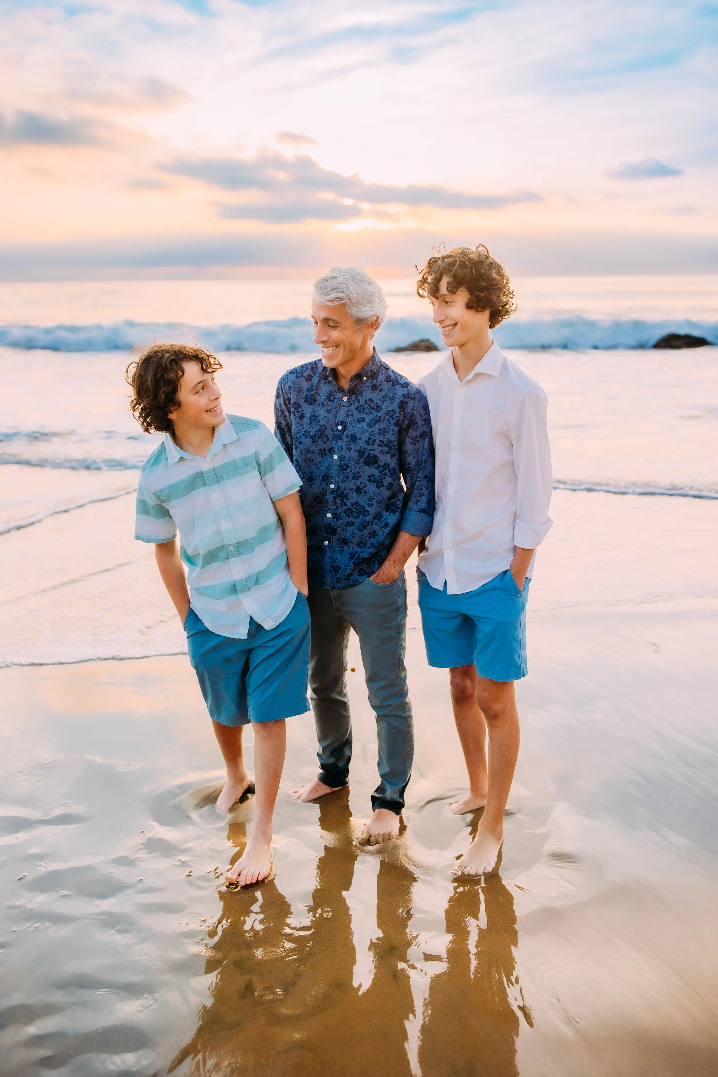 dad and his sons posing together and laughing during their family photos in Orange County, California
