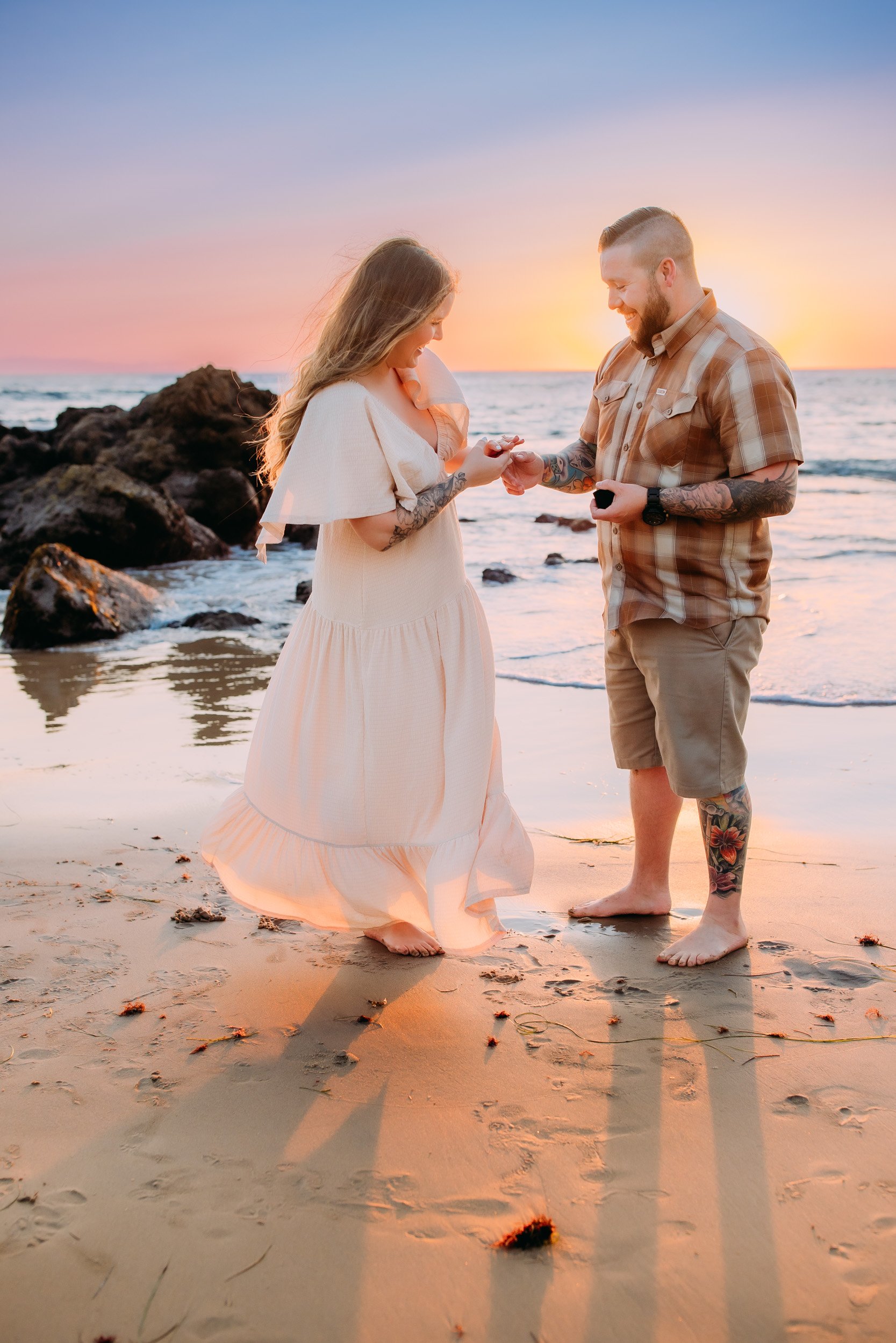 man doing a surprise proposal to his girlfriend during their photo shoot at sunset in Newport Beach, CA