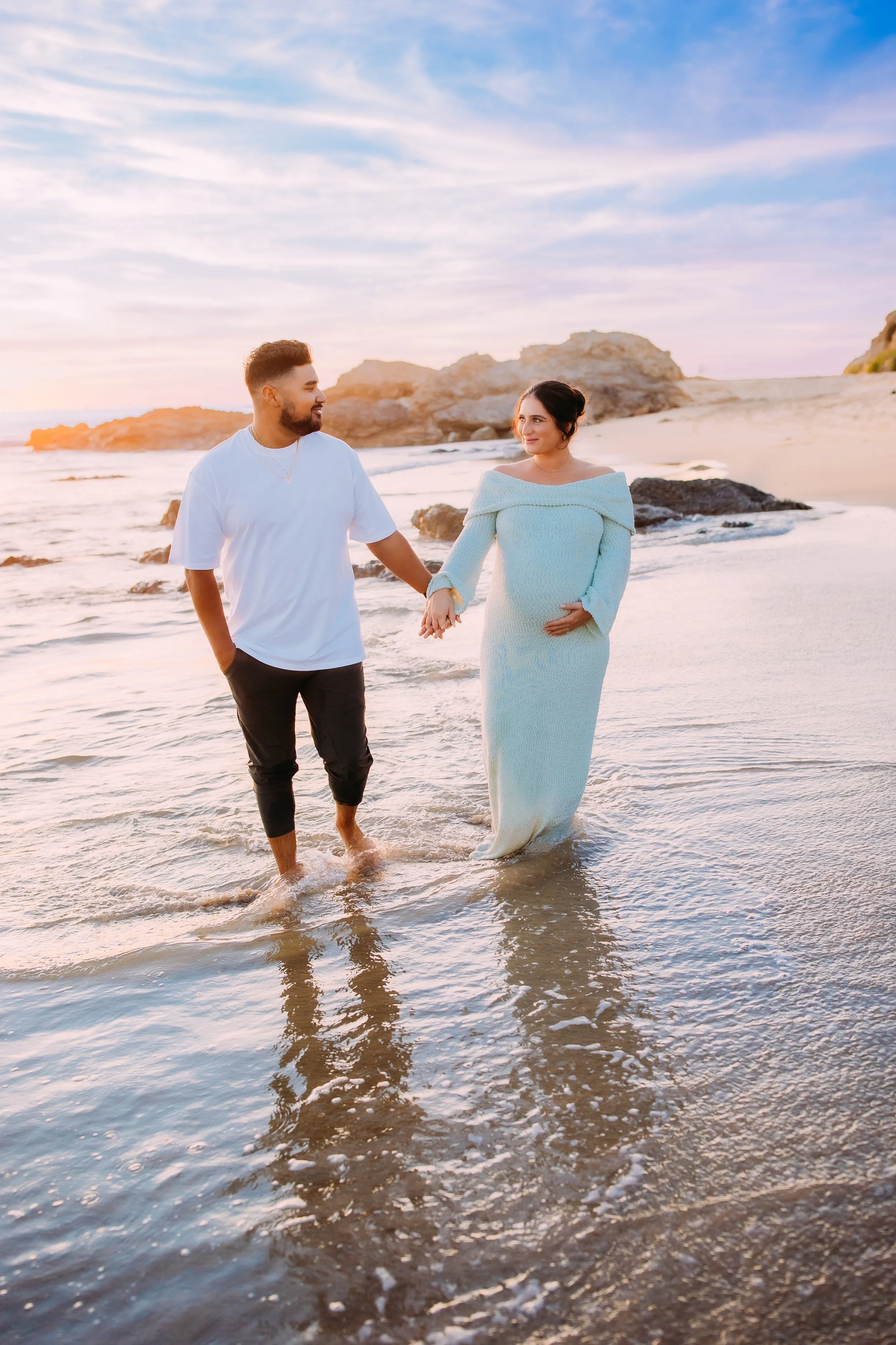 Maternity photos in Newport Beach at sunset with glowing mom and couple on beach