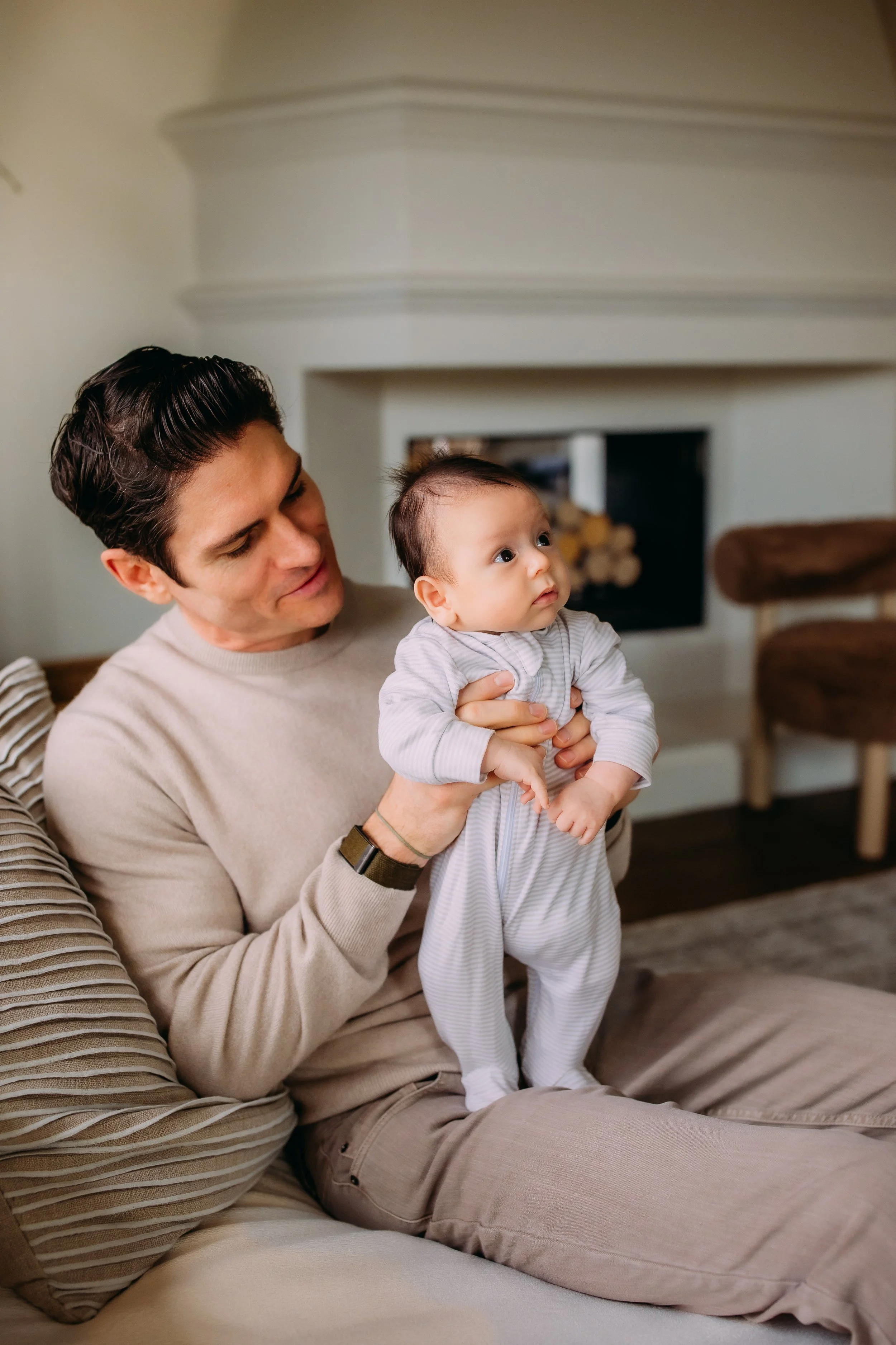 dad holding his newborn baby boy during a mini session in the comfort of their home